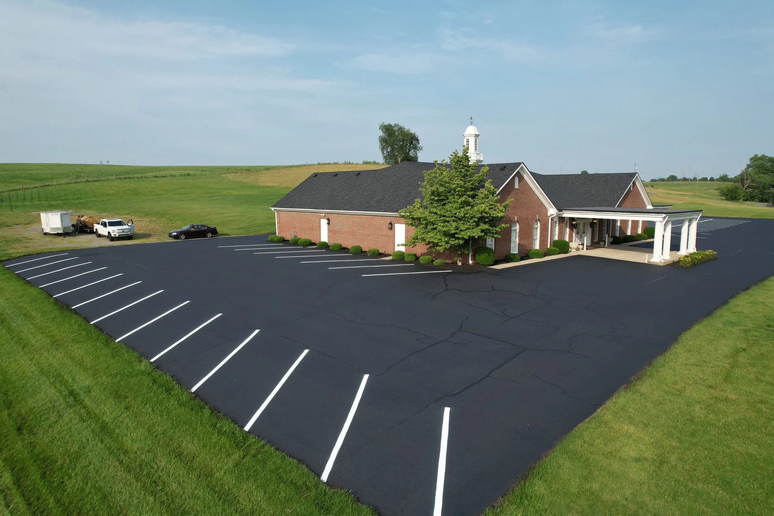 A brick church building with line stripe work and finish sealcoat