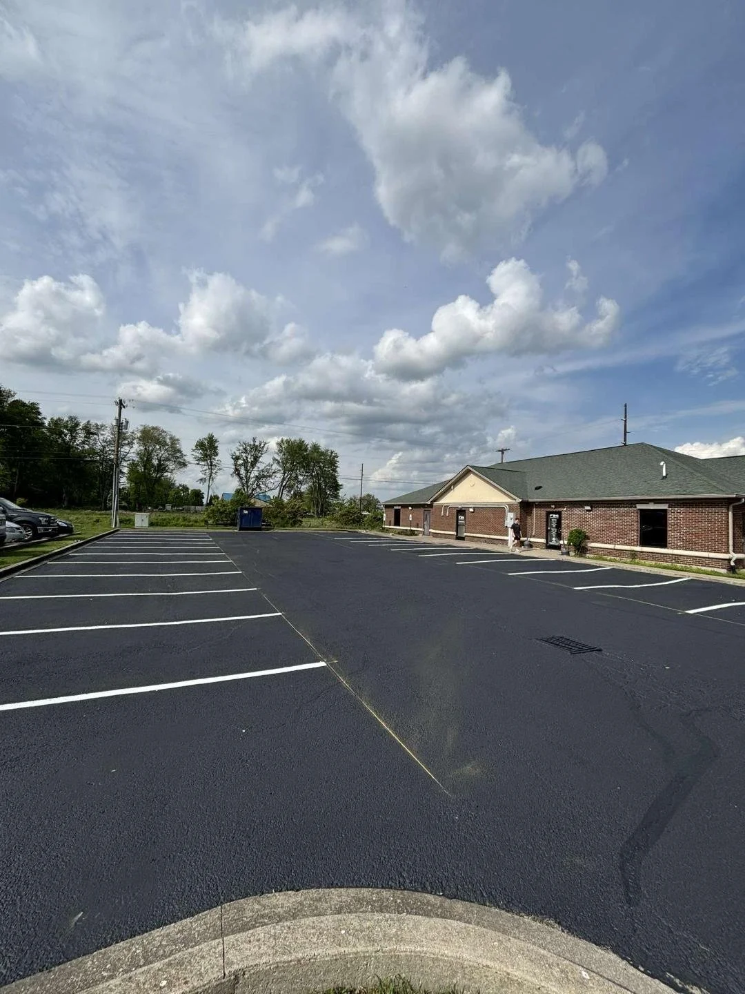 Parking lot with freshly paved black asphalt, white parking space lines
