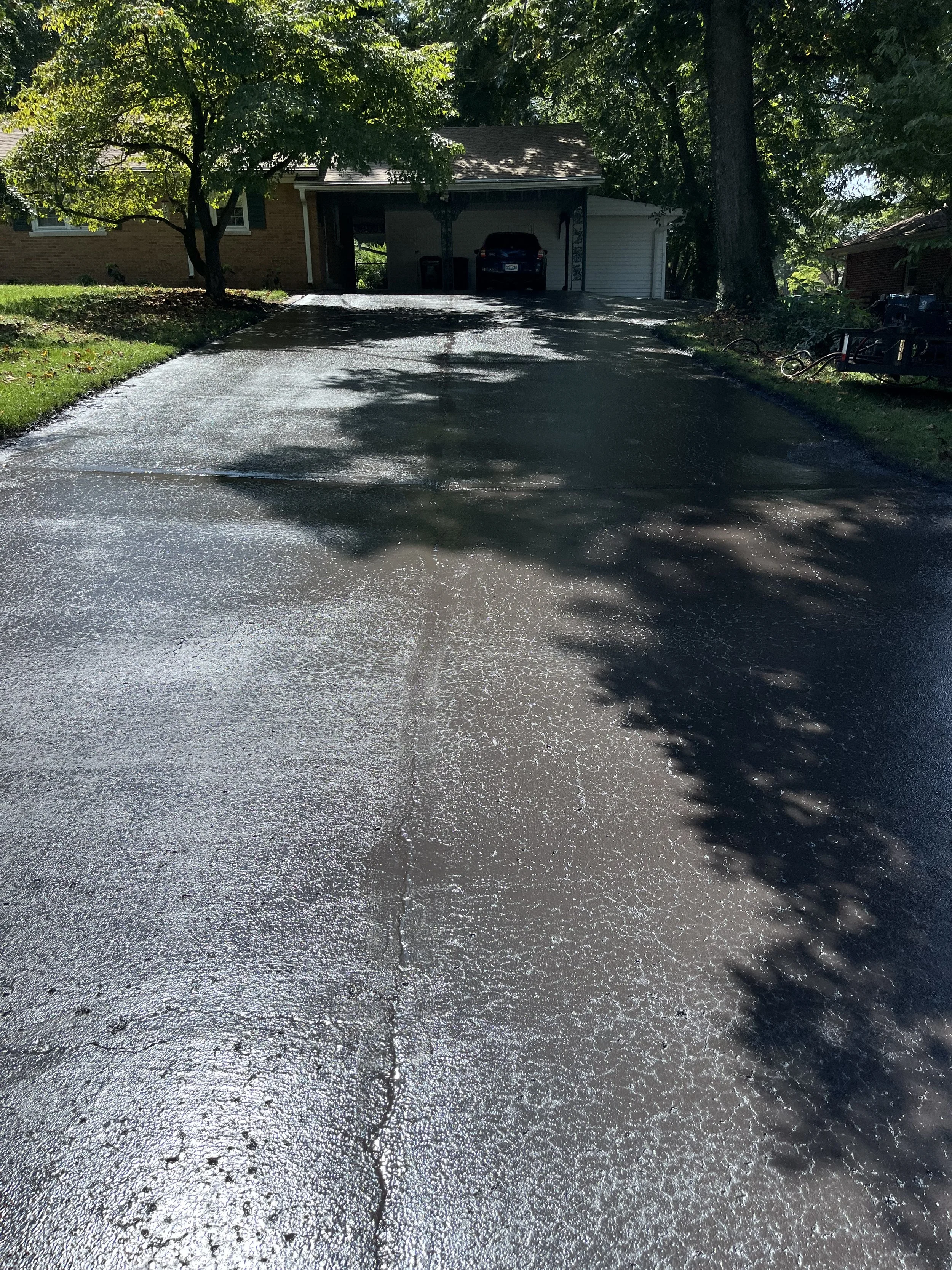 A freshly paved driveway The driveway is wet,