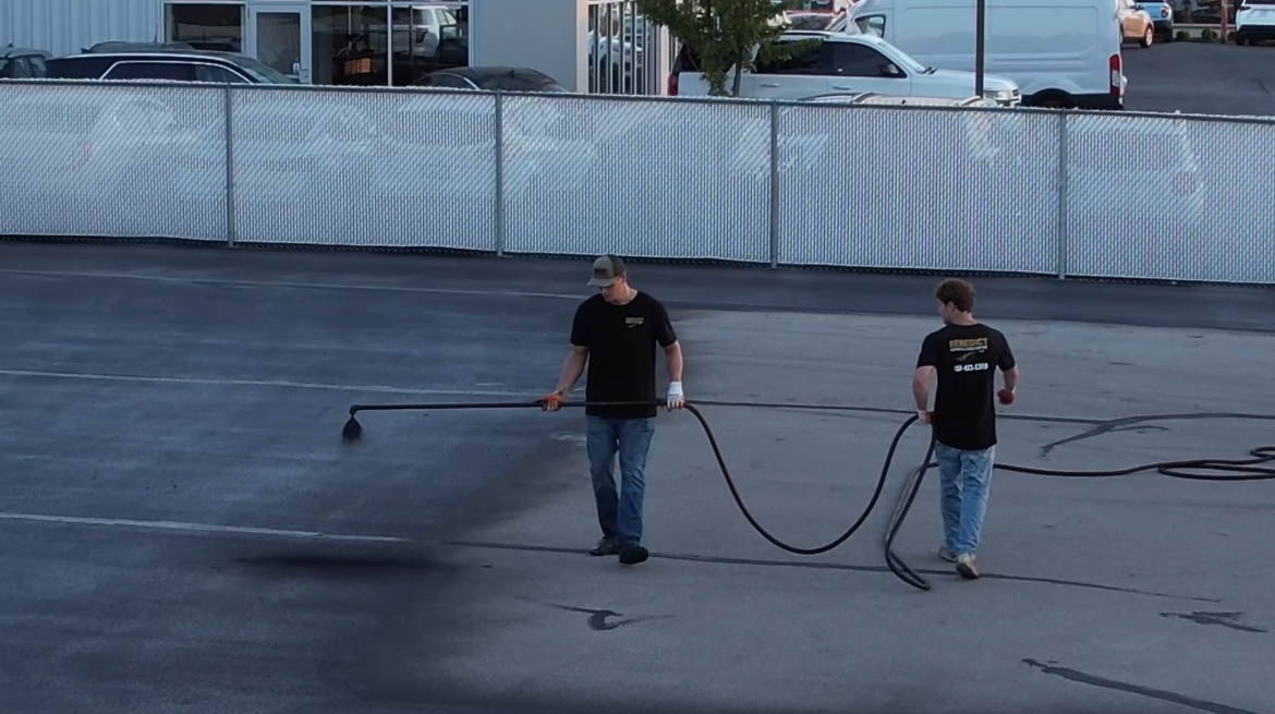 Two men Sealcoating a car dealership