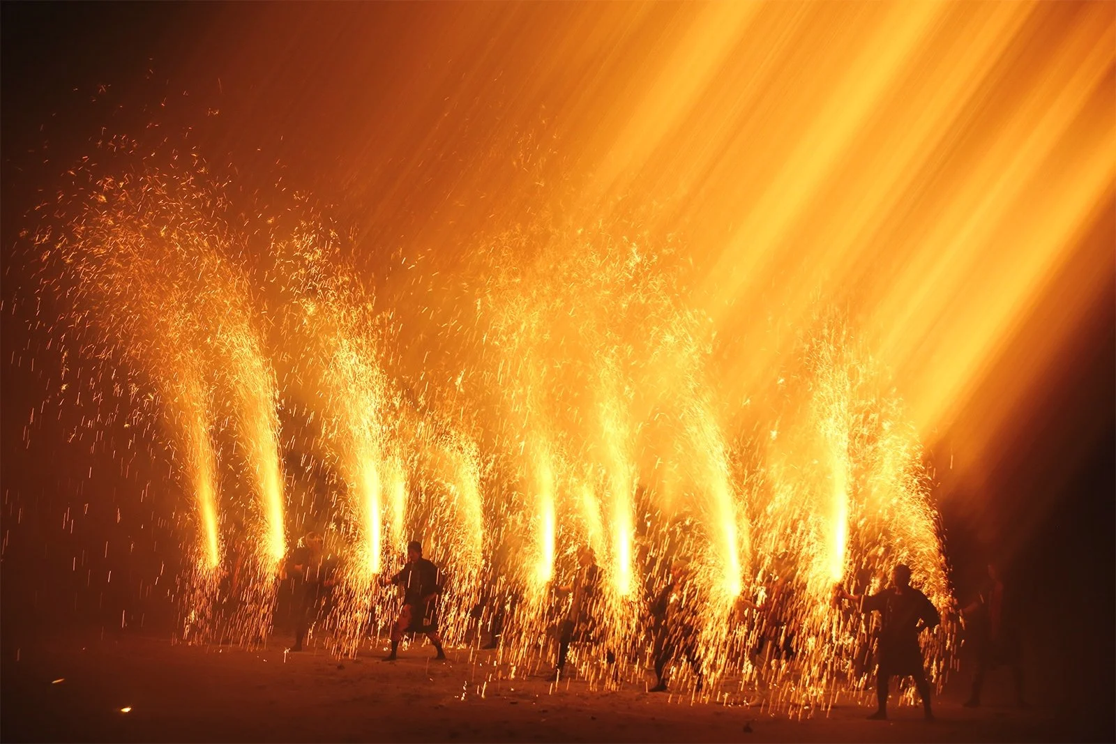 夜空の中で打ち上げられる多くの火花と火の玉を伴う豊橋市の手筒花火