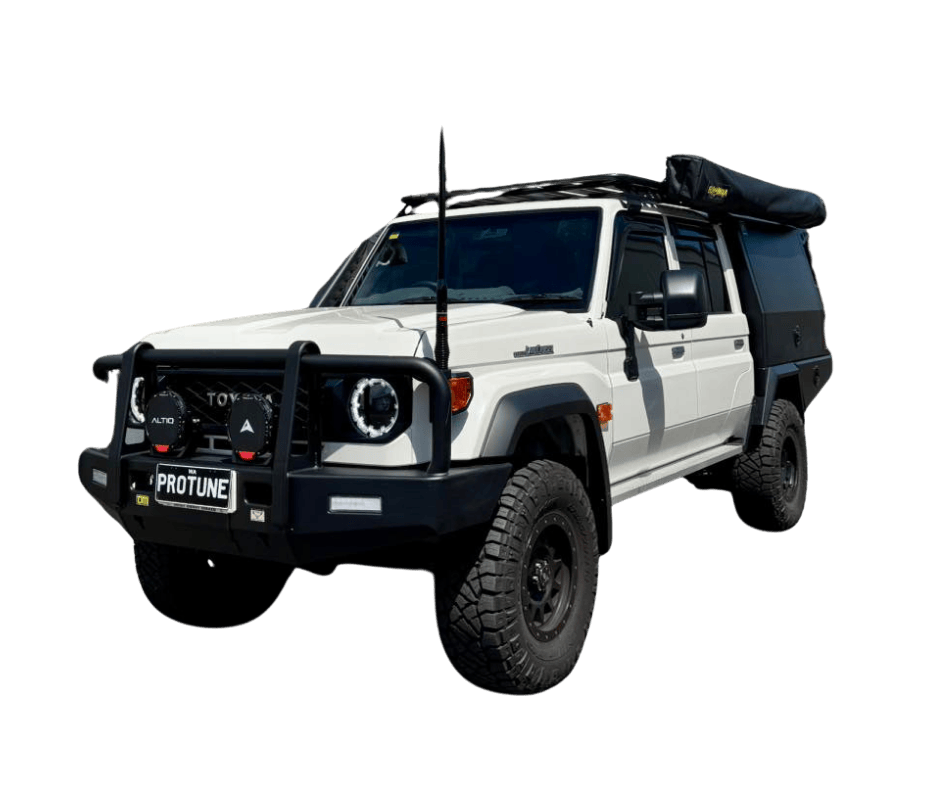 White off-road 79 series land cruiser with front bumper guard, roof rack, and mounted gear on top, set against a black background.