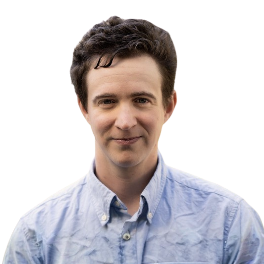 Portrait of A. Feder Cooper with dark brown hair, wearing a light blue button-down shirt, smiling subtly, against a white background.