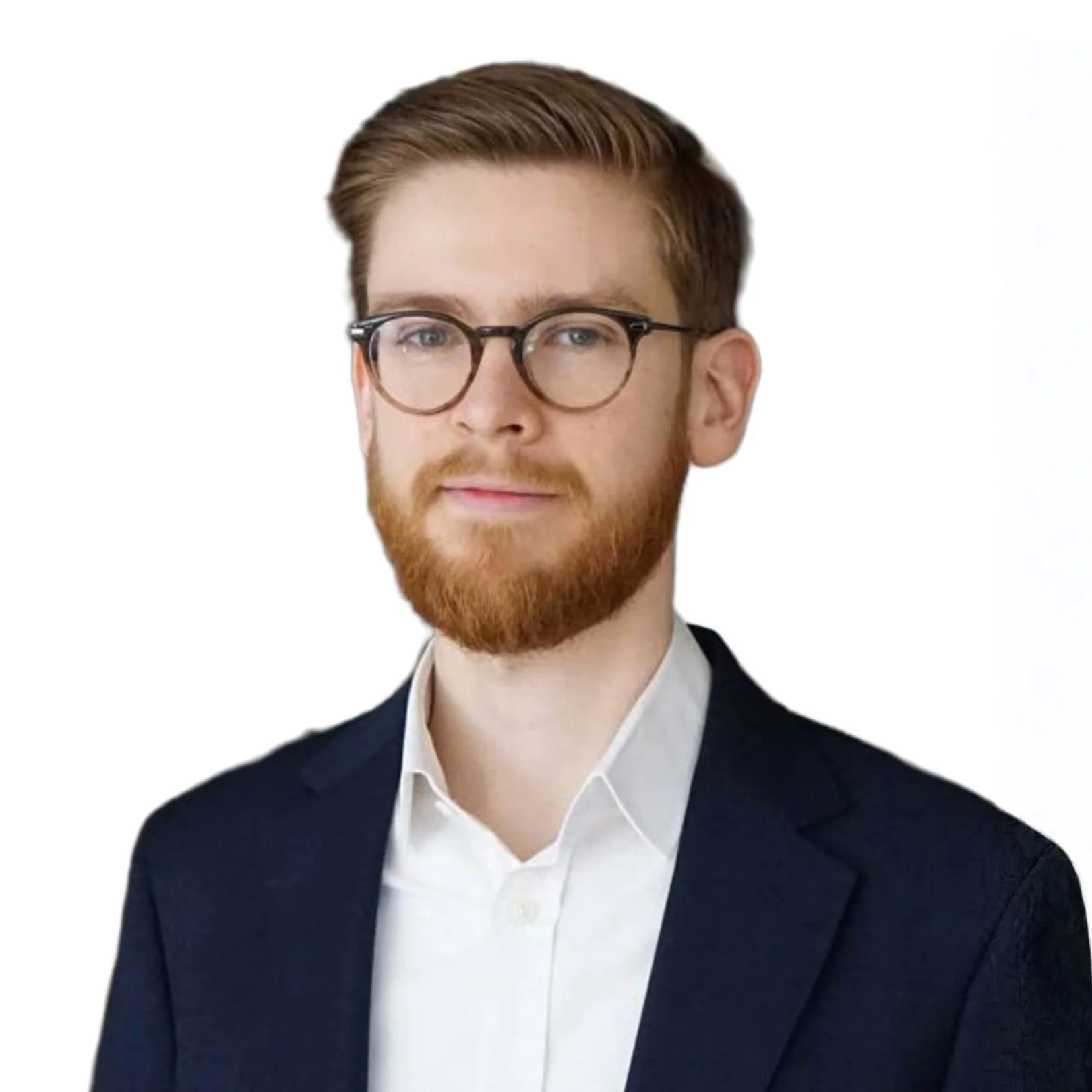 Portrait of George Balston with brown hair, glasses, and a beard, wearing a dark blazer and white shirt, against a plain white background.