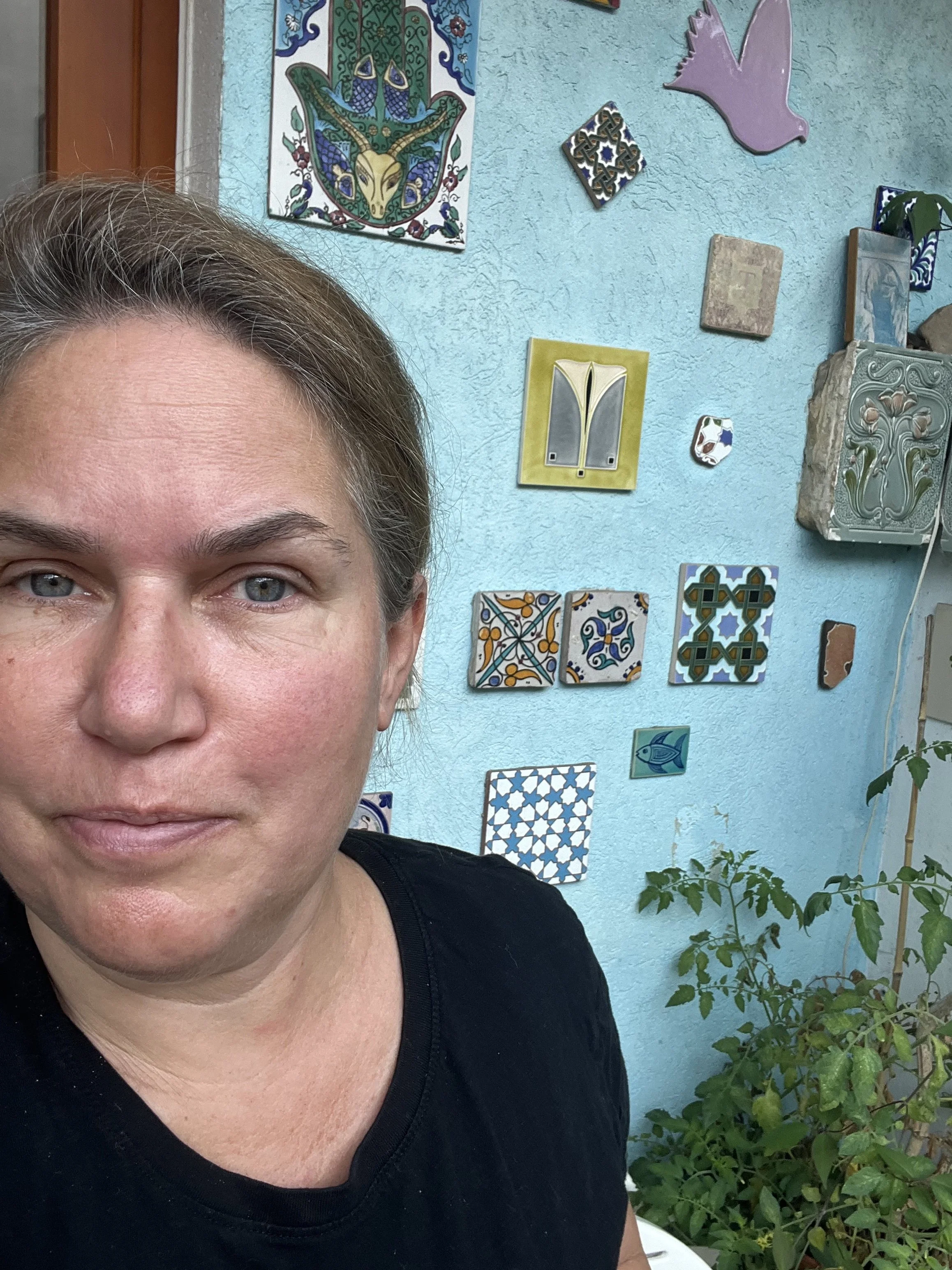 Sona Terlohr, Elterncoachin, vor einer Wand mit diversen Kacheln