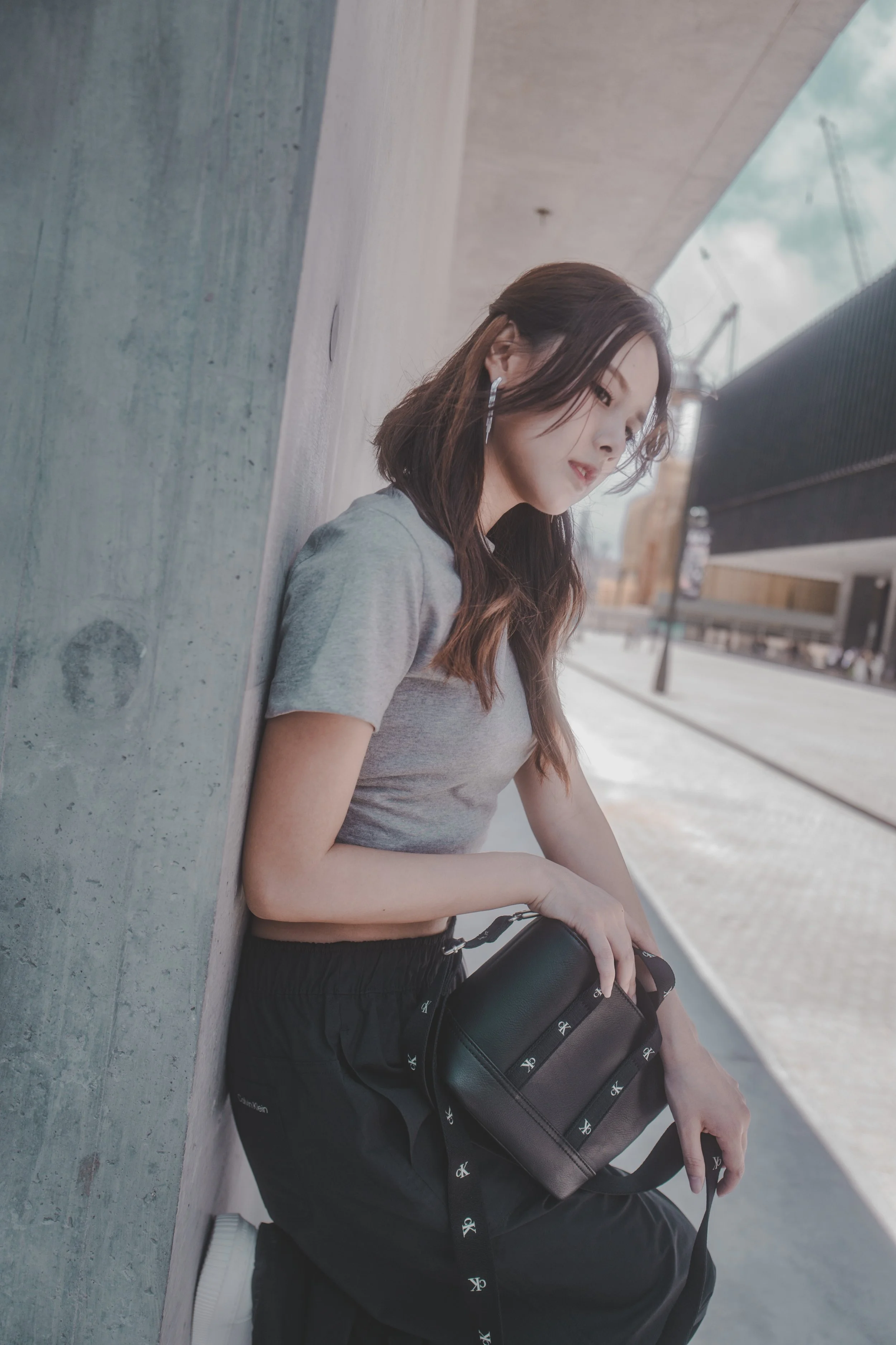 Model wearing Calvin Klein apparel and carrying a black bag during a fashion commercial shoot by SpeedUp.