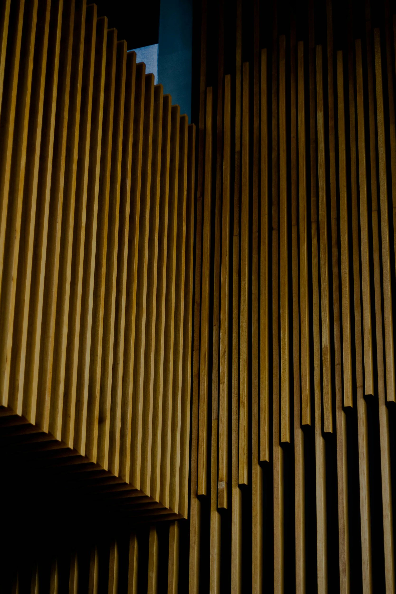 Close-up of wooden slats arranged vertically in a modern architectural design.