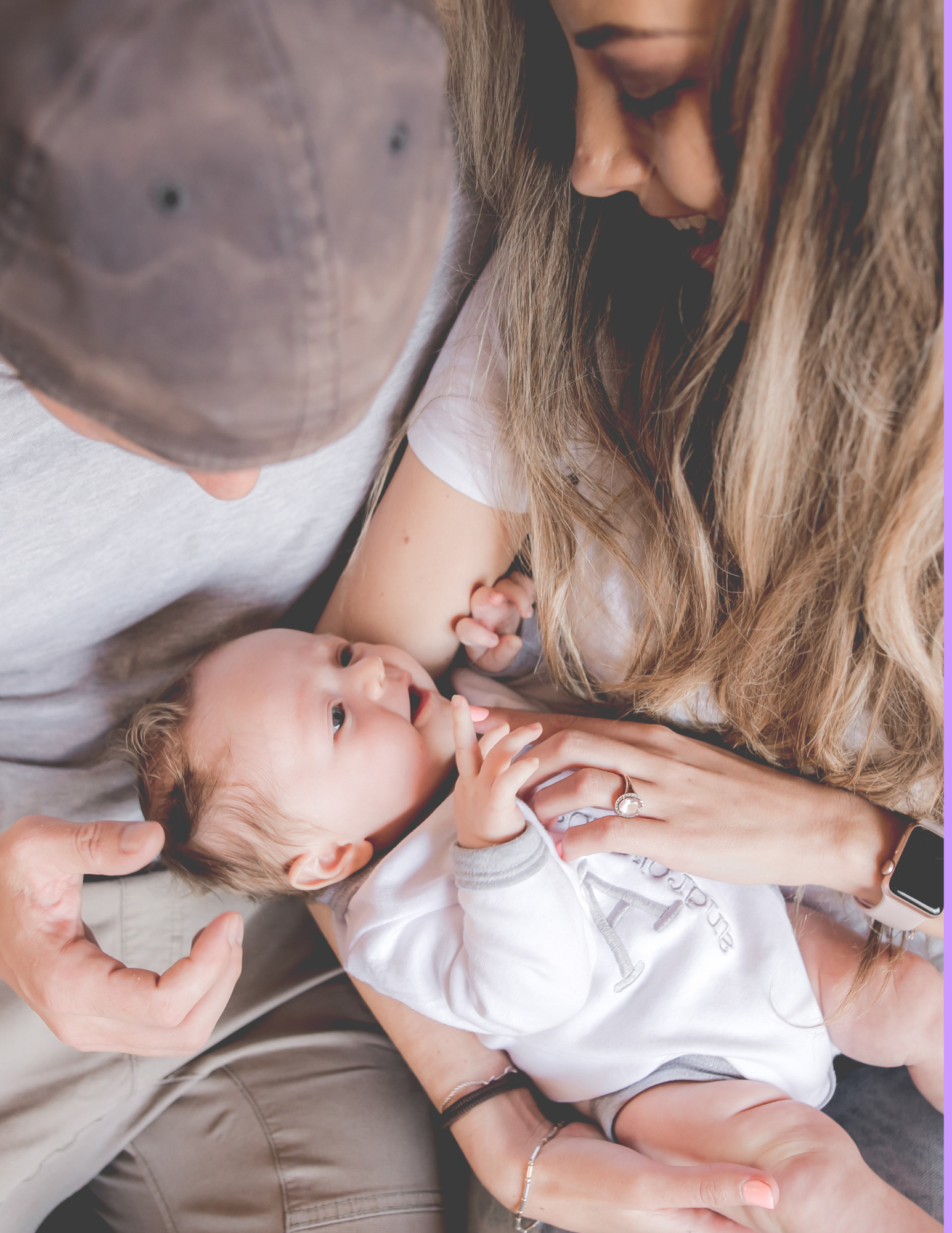 A young family with a mother, father, and baby lying close together in a cozy setting, sharing a tender moment.