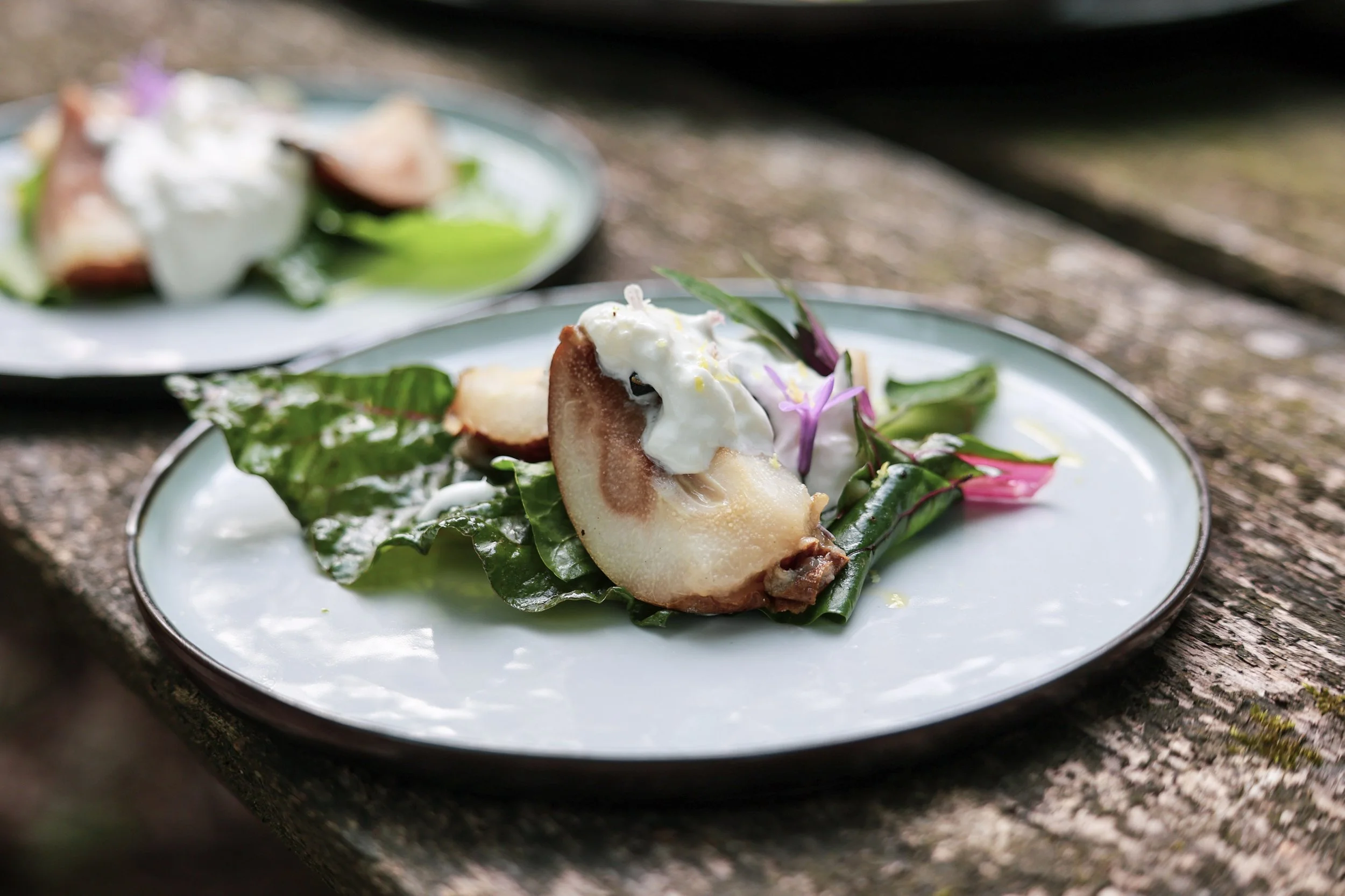 Duurzaam cateringgerecht van Shift Catering: salade met seizoensgroenten, geserveerd op een houten tafel.