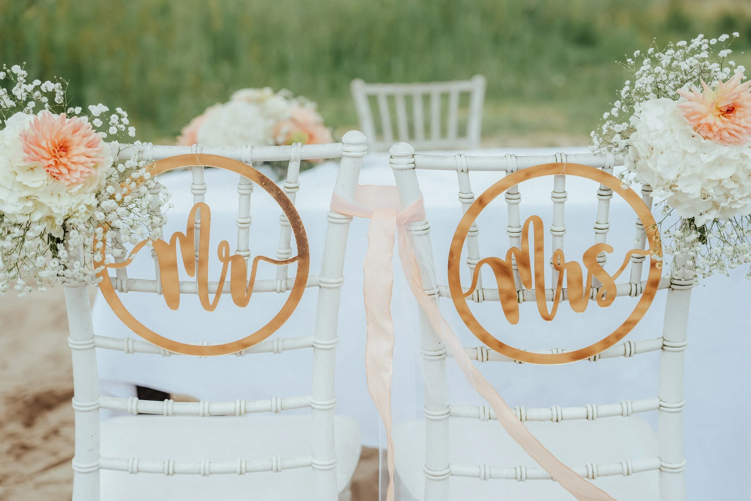 Hochzeitstisch mit weißen Stühlen, Blumen, "Mr" und "Mrs"-Schildern aus Holz, auf einer Wiese in Kiel und Flintbek