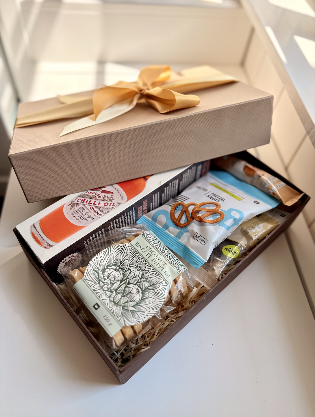 A St. Patrick's Day themed gift basket containing gold chocolate coins, two cans of Guinness beer, a pack of Spearmint gum, a box of Magn| Luxury Gift Wrapping & Custom Hampers