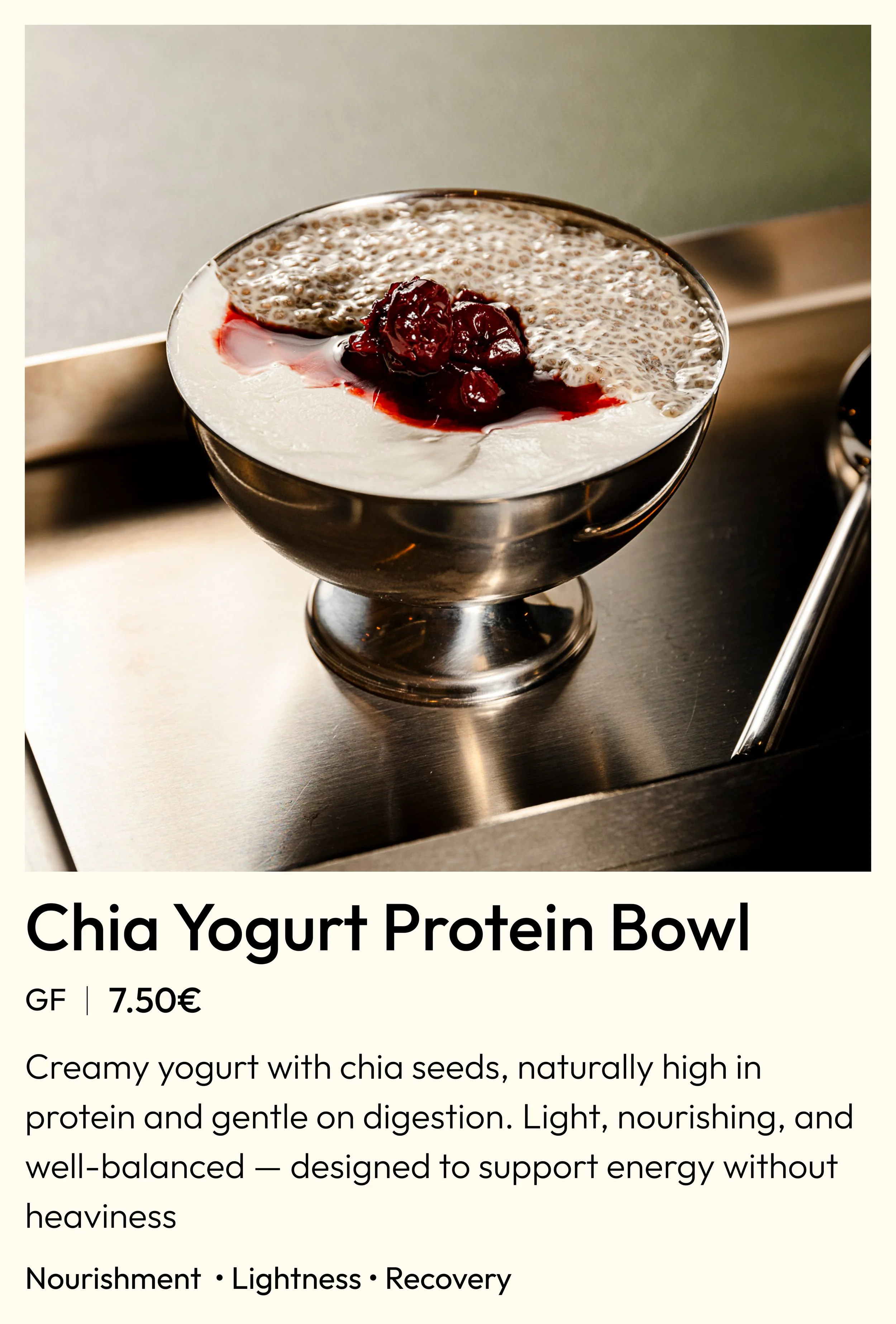 A stainless steel bowl of chia yogurt topped with cherry or berry compote, placed on a metallic surface, with a label describing it as 'Chia Yogurt Protein Bowl' for 7.50 euros, highlighting its creamy texture, high protein content, and digestive benefits.
