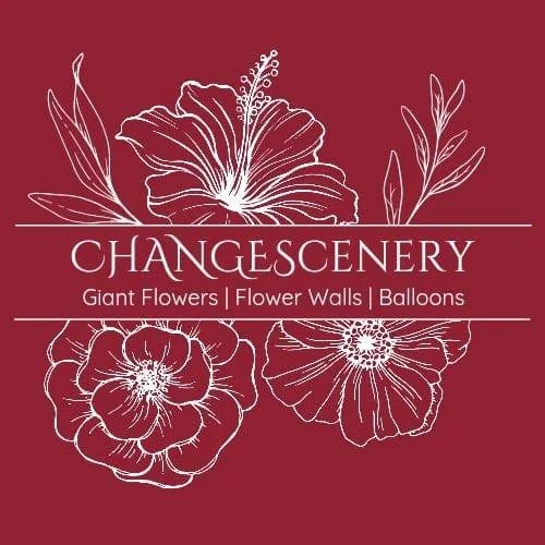 Logo for ChangesCenery featuring white line drawings of a large lily, a flower, and some leaves on a maroon background, with text about giant flowers, flower walls, and balloons.