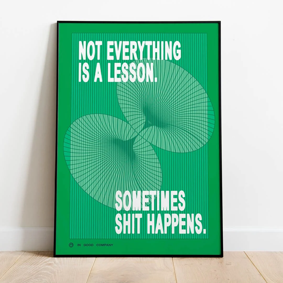 Framed poster with the quote, "NOT EVERYTHING IS A LESSON. SOMETIMES SHIT HAPPENS." in white text on a bright green background with vertical lines and two abstract, overlapping, patterned ovals.
