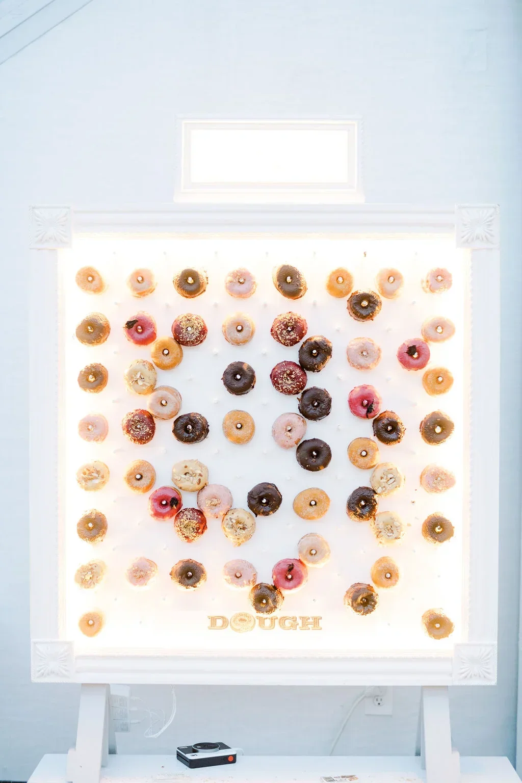 Elegant wedding donut wall at Brooklyn Botanic Garden Palm House featuring colorful donuts, unique wedding dessert display, and entertainment by Aria Melody DJ, the best wedding DJ in NYC, Brooklyn, and New Jersey for non-traditional celebrations.