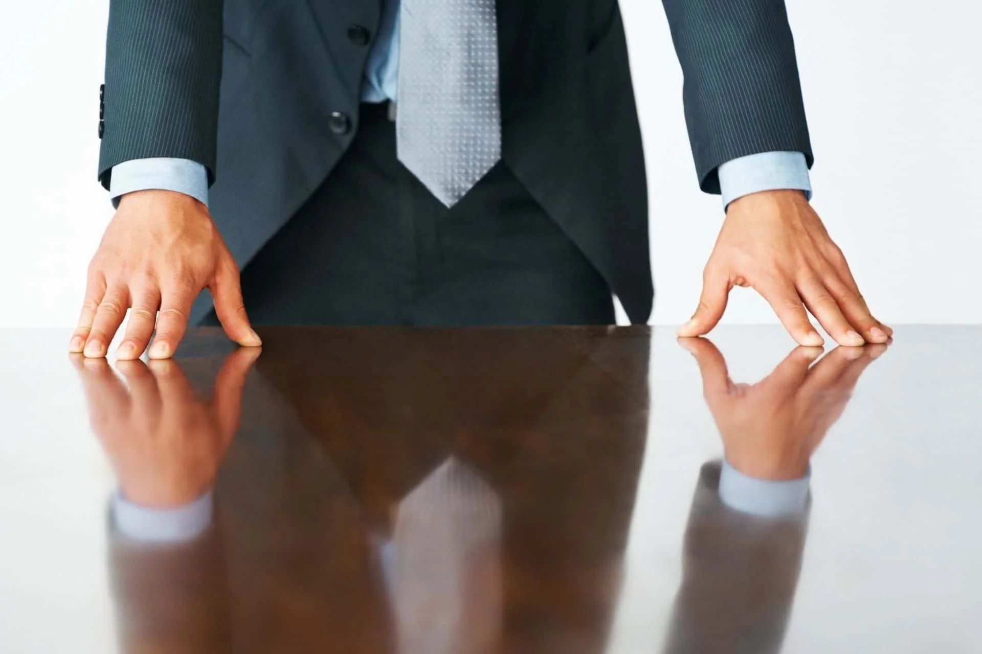 executive in a suit and tie with his hands on the table