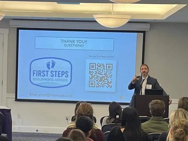 Caregive/Parent training and support and A man giving a presentation to an audience in a conference room with large windows and a projection screen.