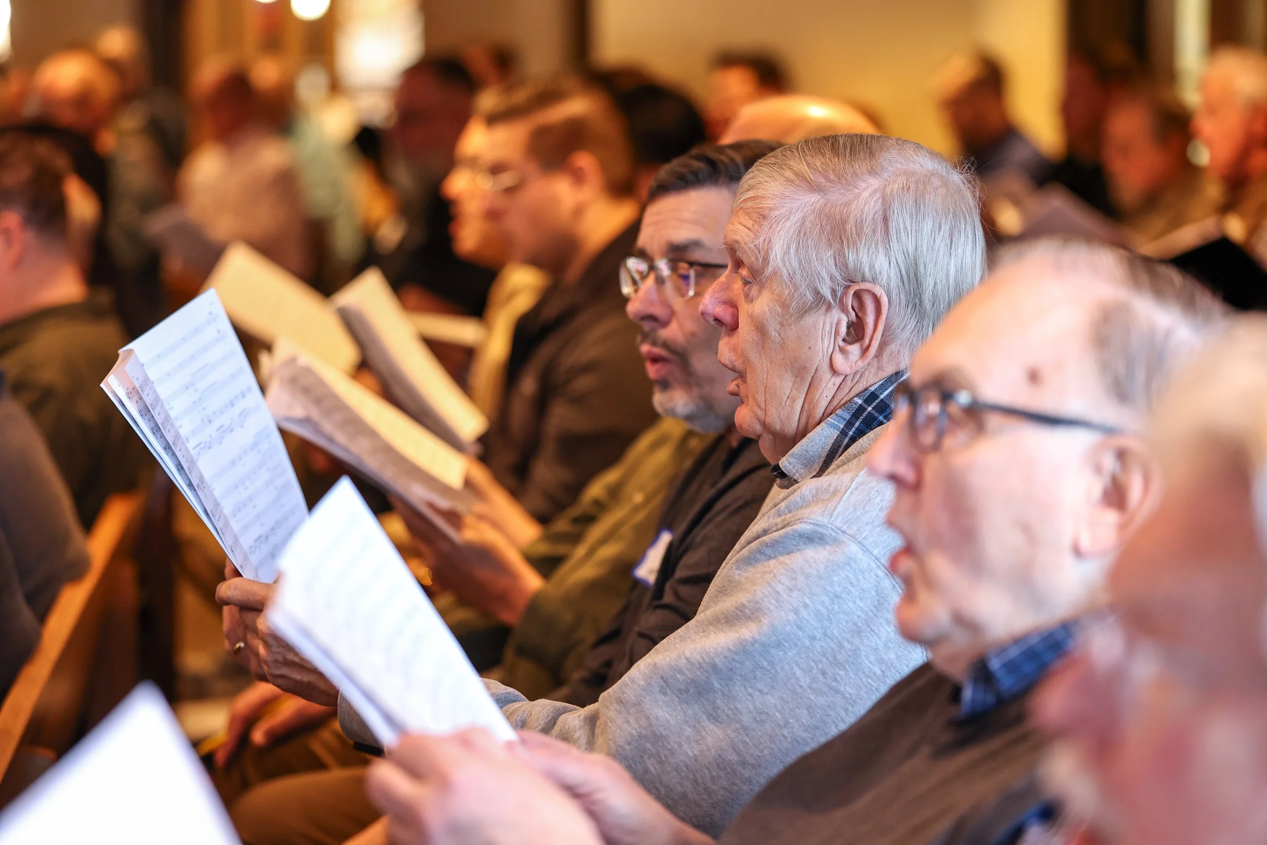 Group of men singing holding music