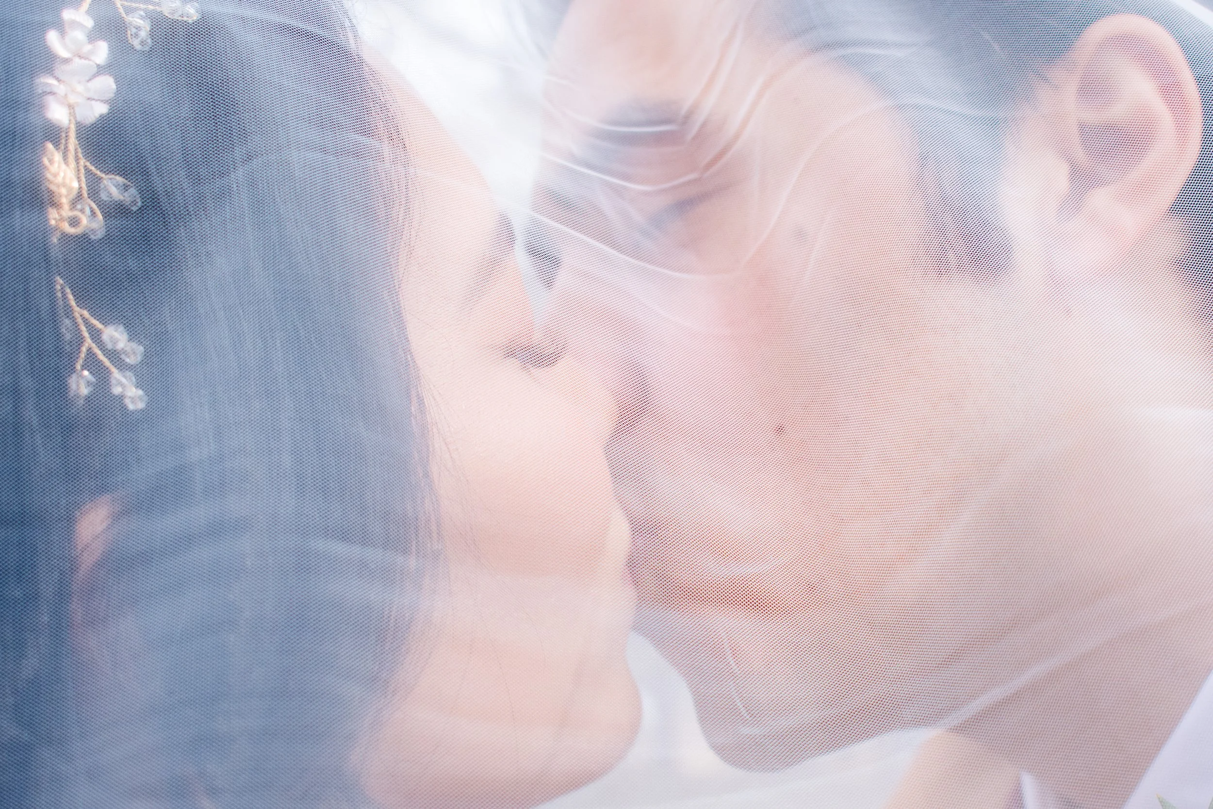 Close-up of two people kissing through a sheer fabric,