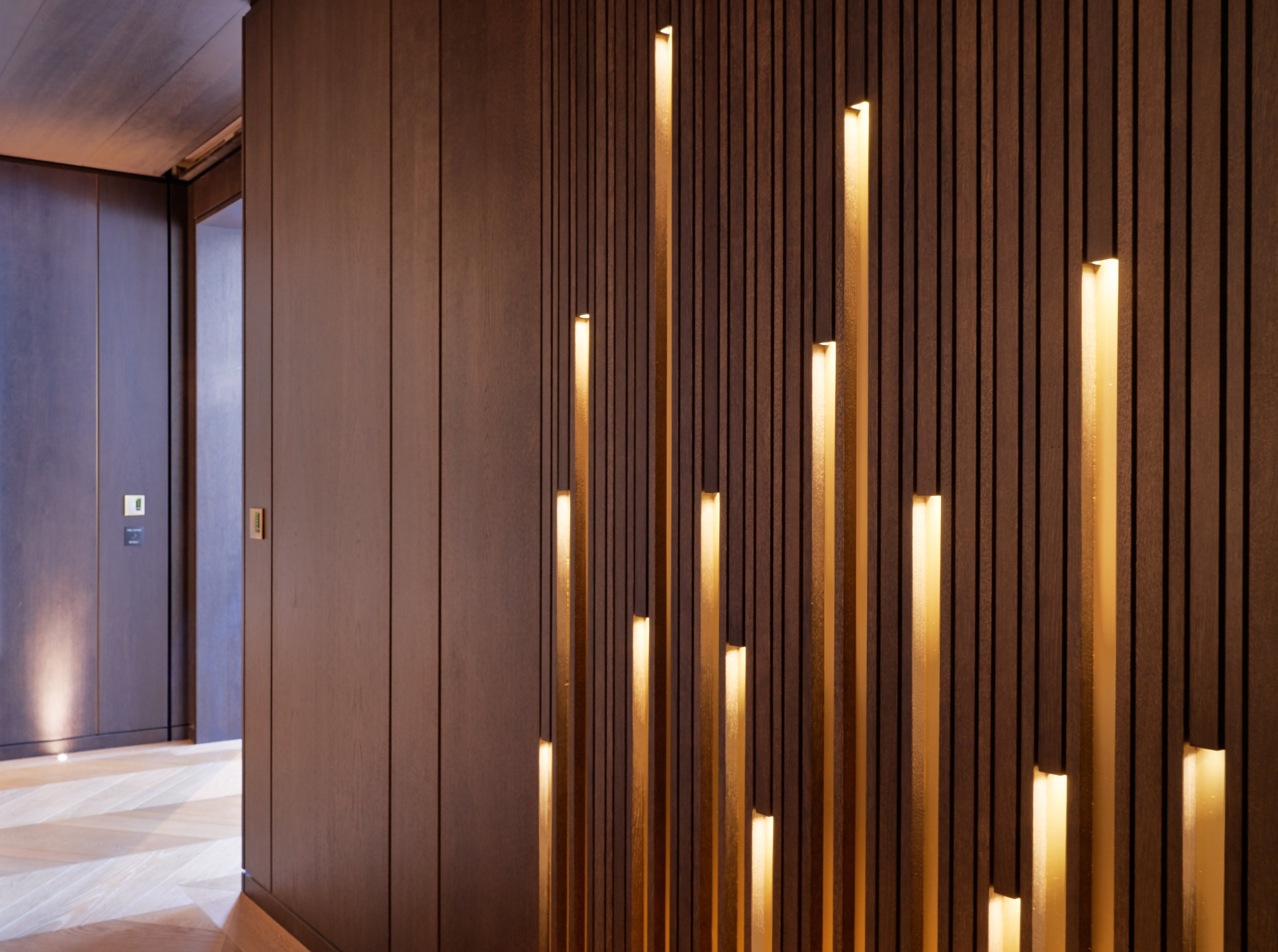 Wooden wall with vertical light strips in modern interior