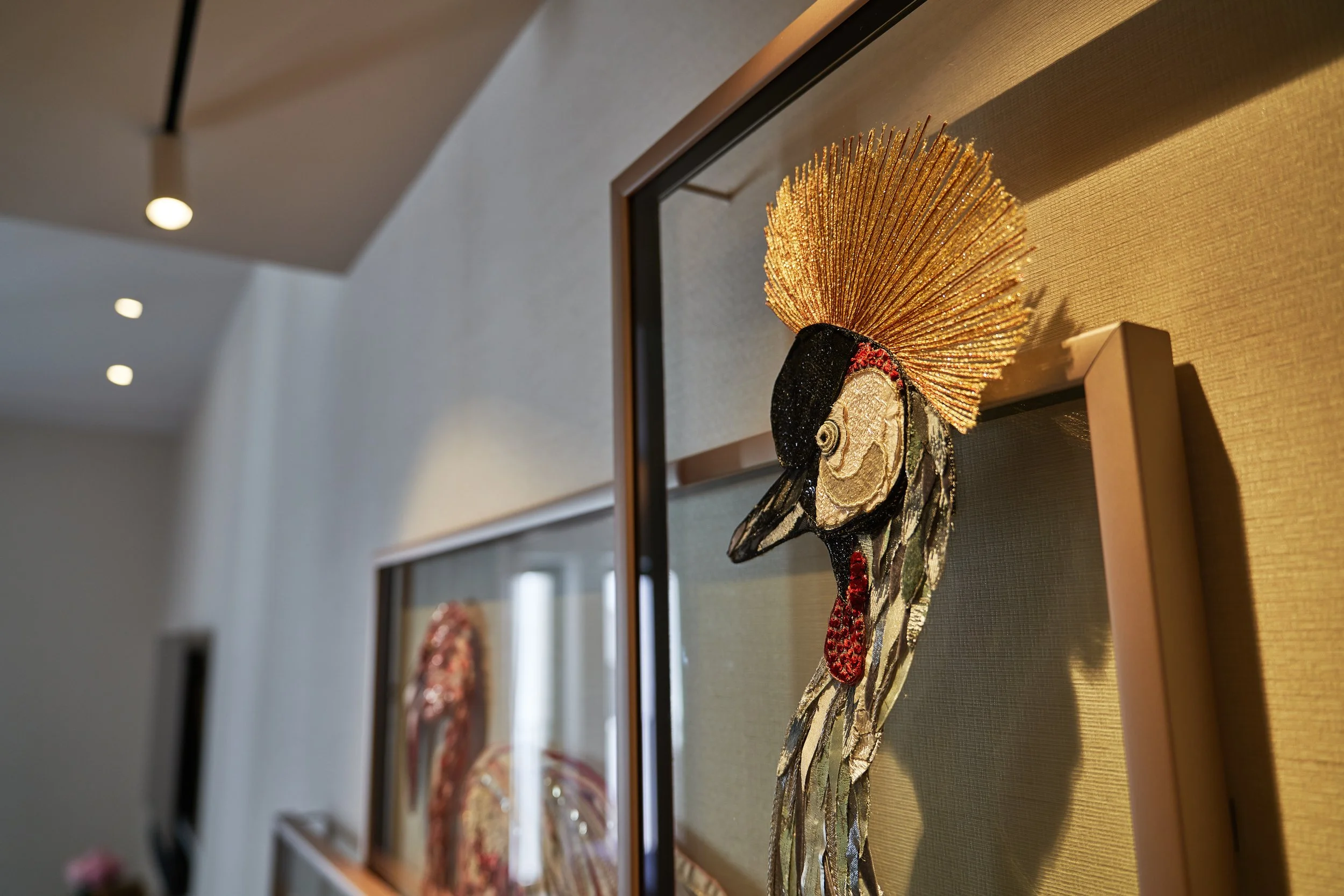 Framed decorative artwork of a bird with a golden crest