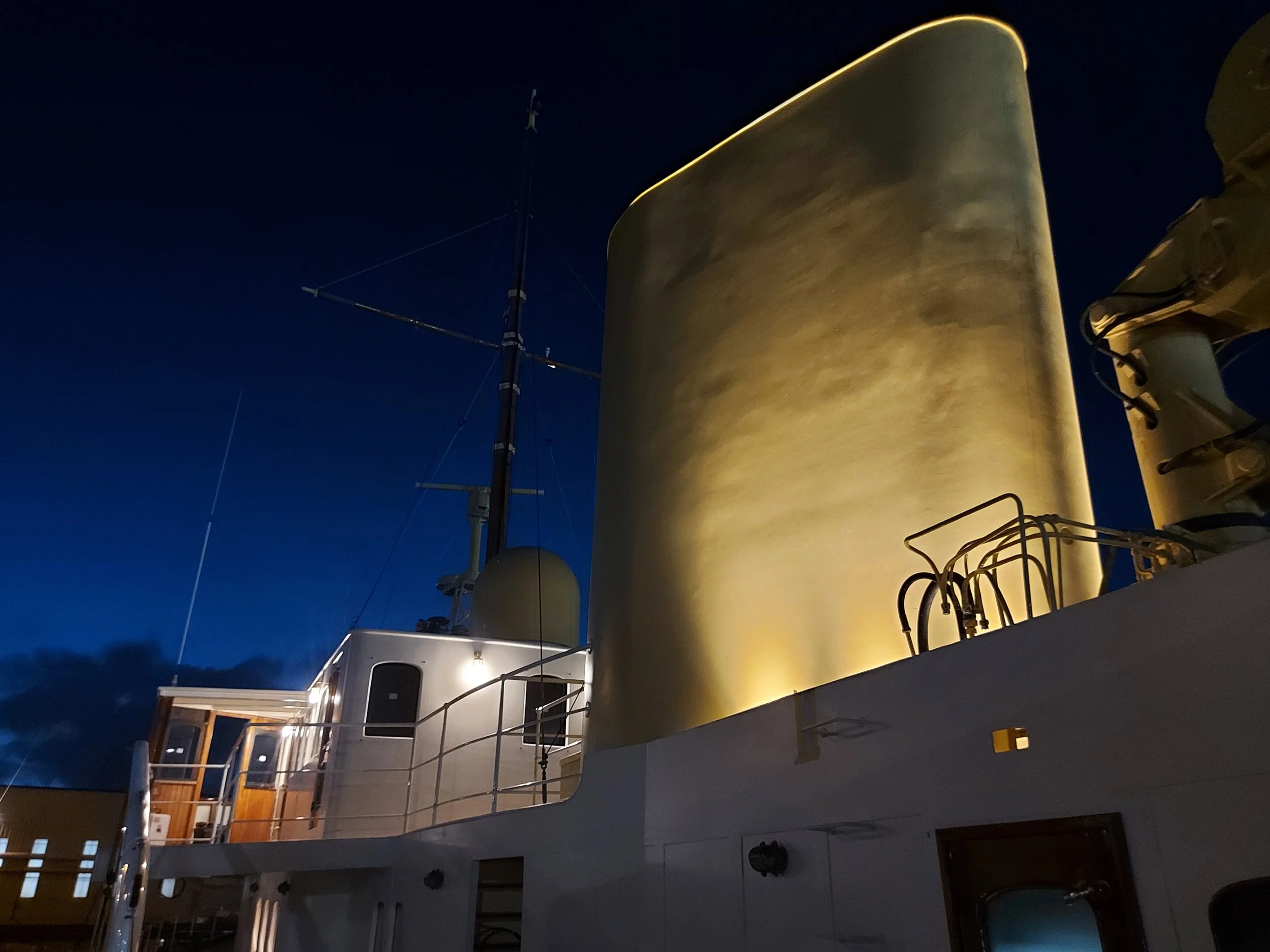 Illuminated ship funnel and cabin exterior at night
