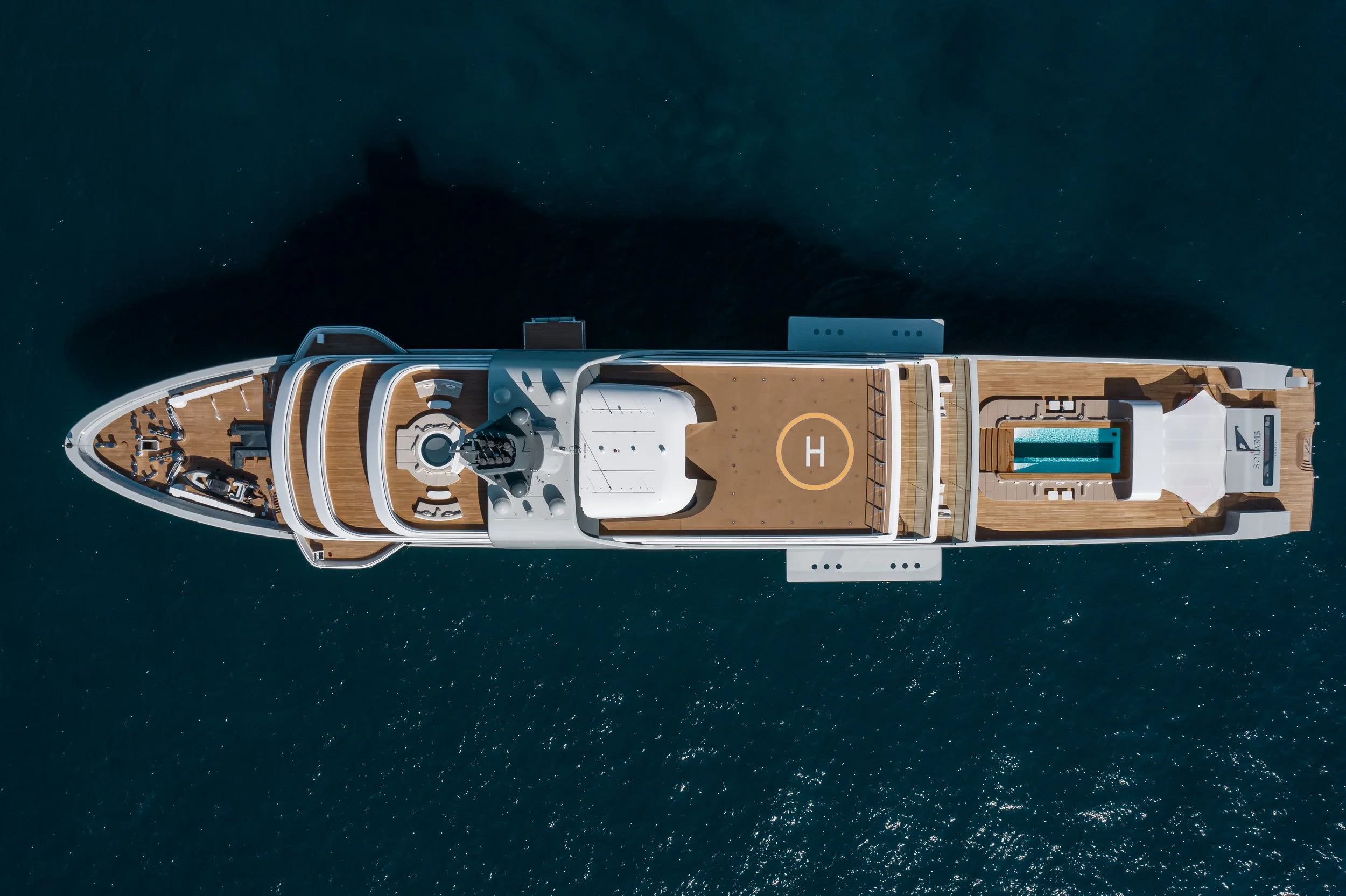 Aerial view of a luxury yacht with helipad and swimming pool.