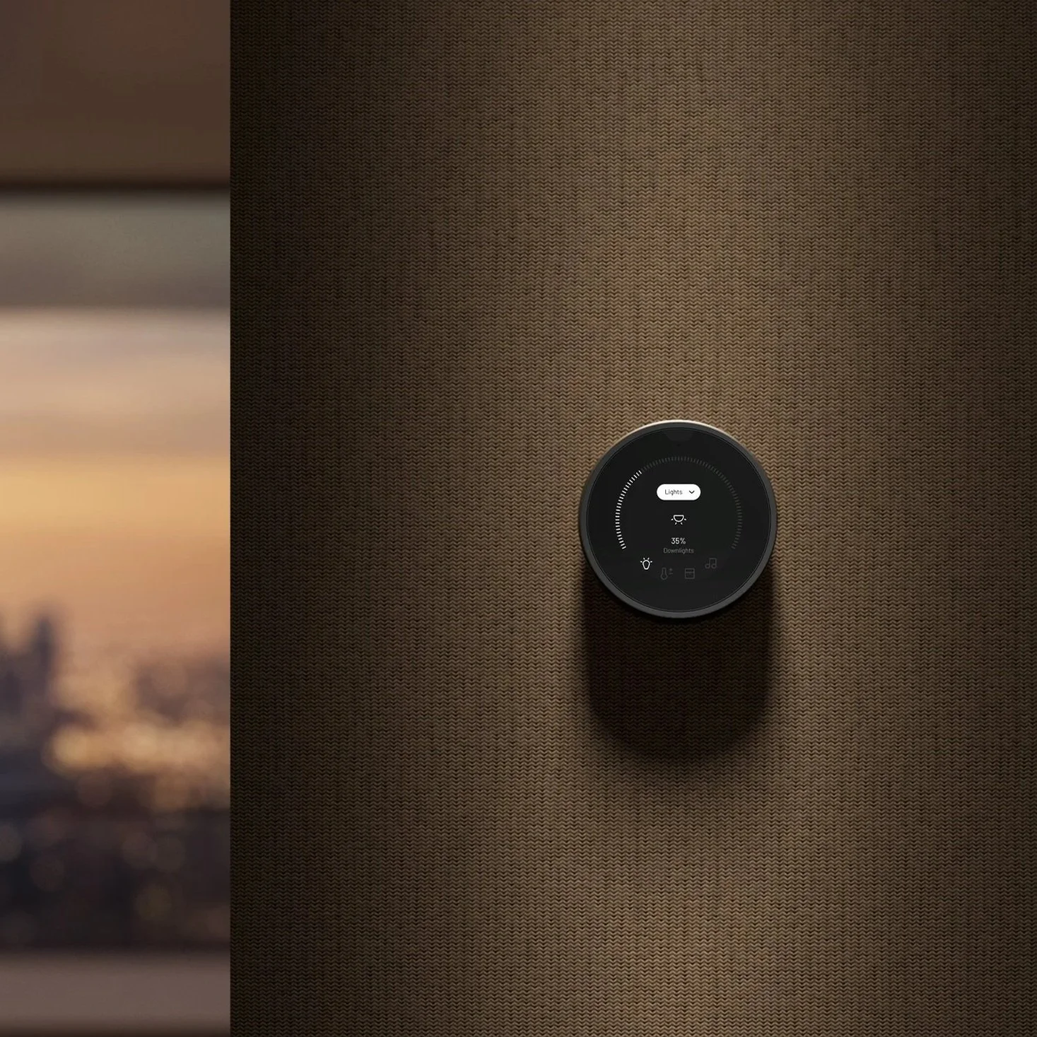 Smart thermostat mounted on a textured brown wall, displaying a temperature of 35% and a brightness setting, with a sunset scene blurred in the background.