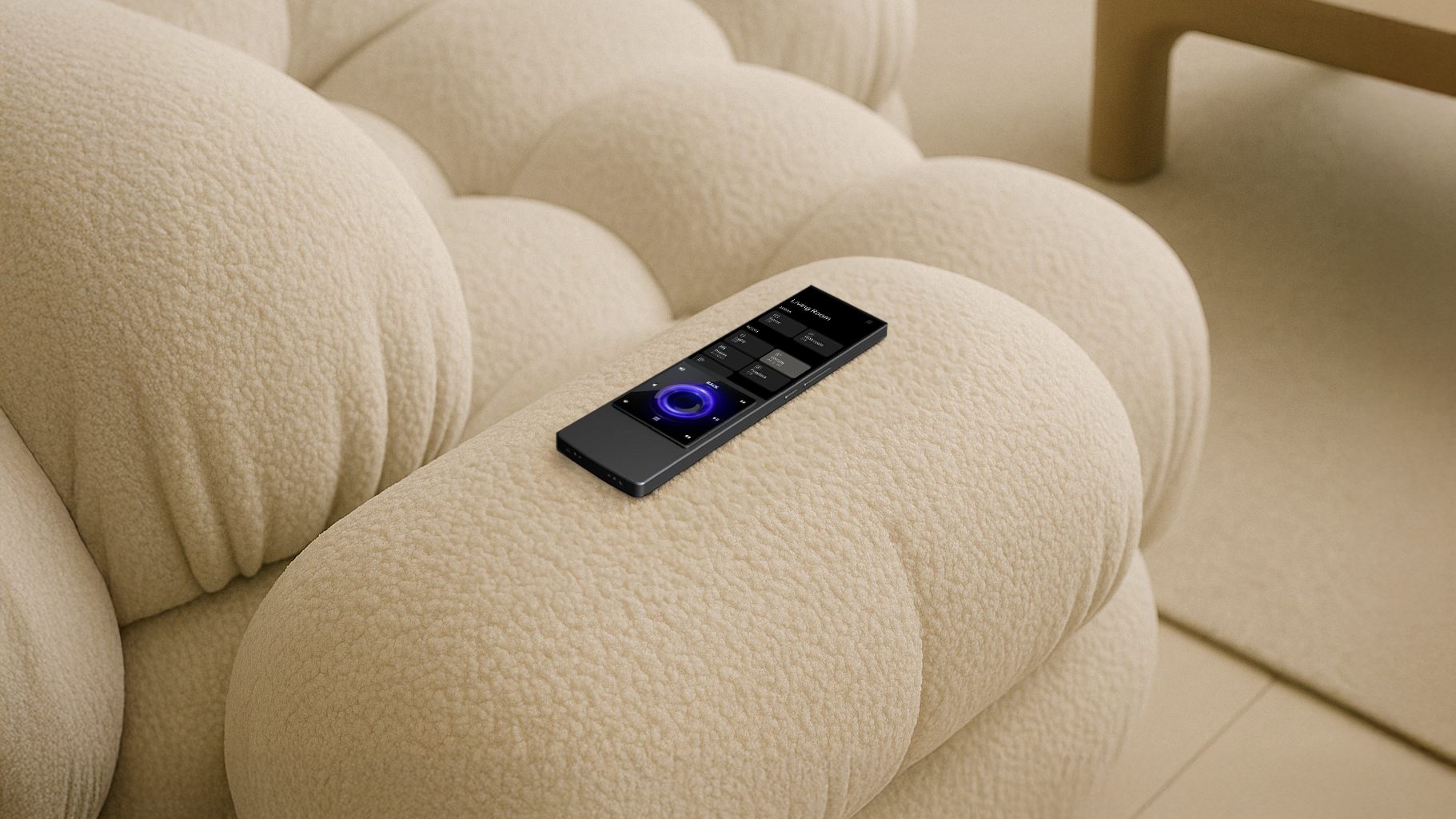 An AVA remote control with ORO integrations with touch screen and buttons resting on a beige, textured, plush sofa.