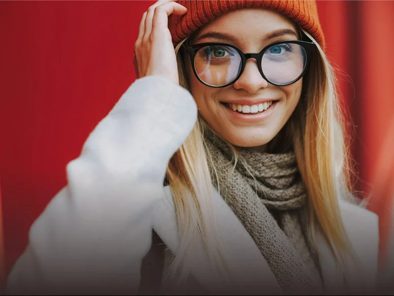 A smiling young woman with large black frames