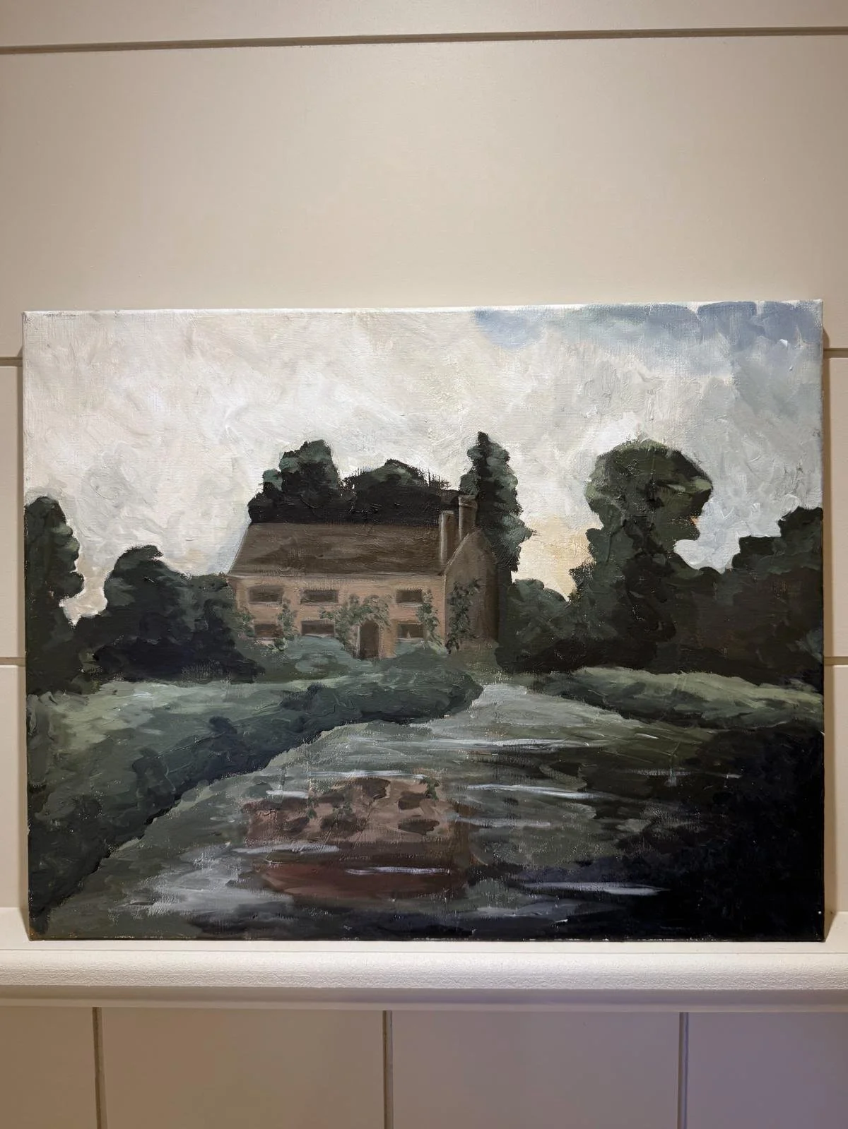 A landscape painting of a house surrounded by trees, with a cloudy sky and a stream or river in the foreground.