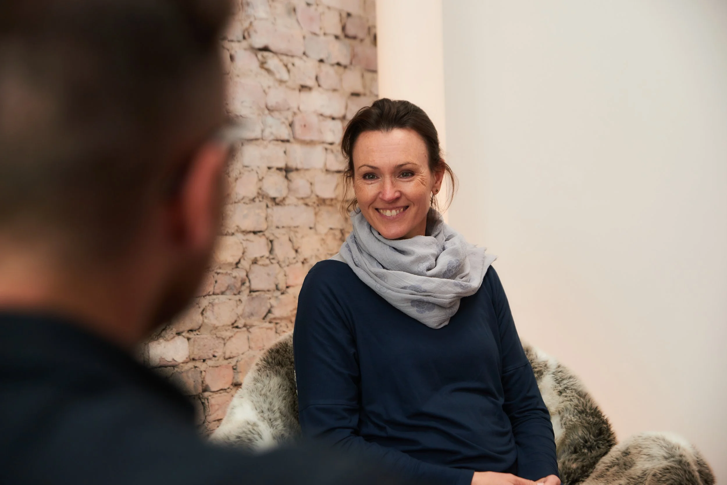 Miriam Wiese, braunhaarige lächelnde Frau im Gespräch mit Klient