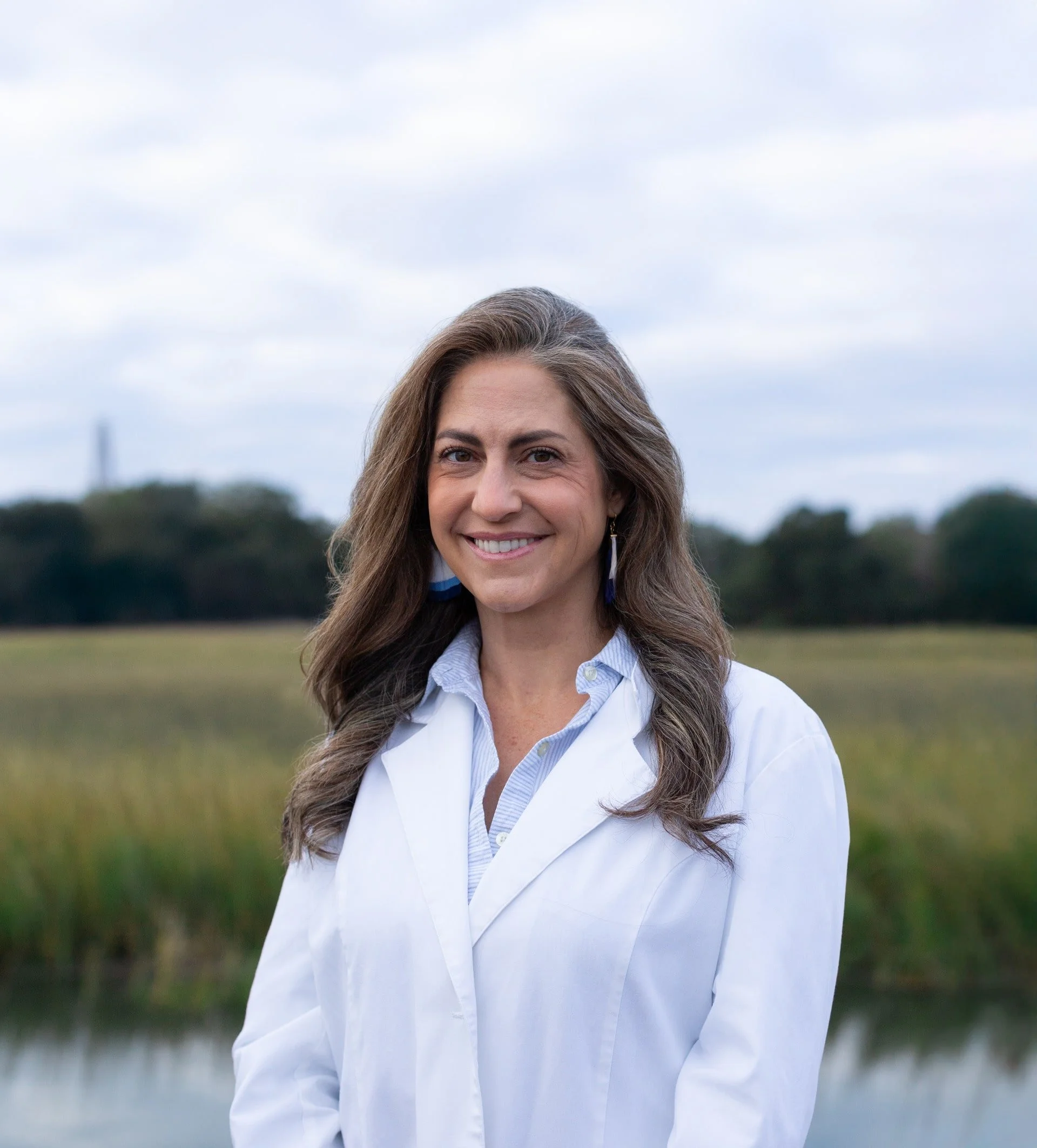 Headshot of Dargan against a marshy background and cloudy sky.