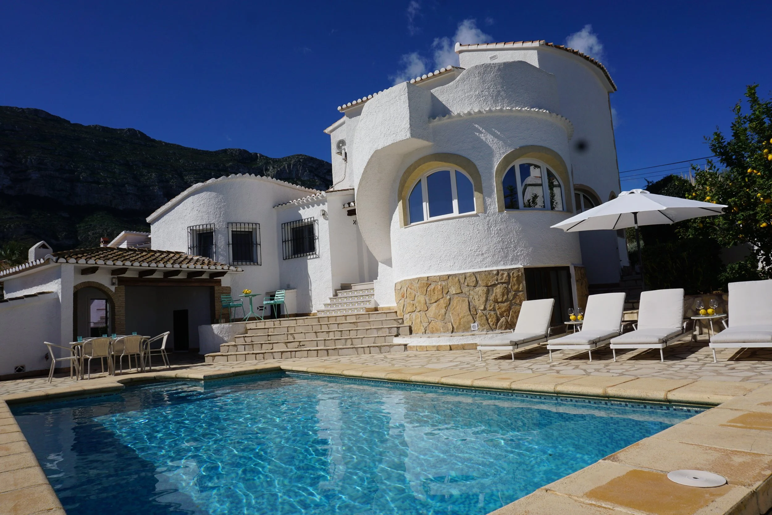 Zicht op het huis en azuurblauwe zwembad