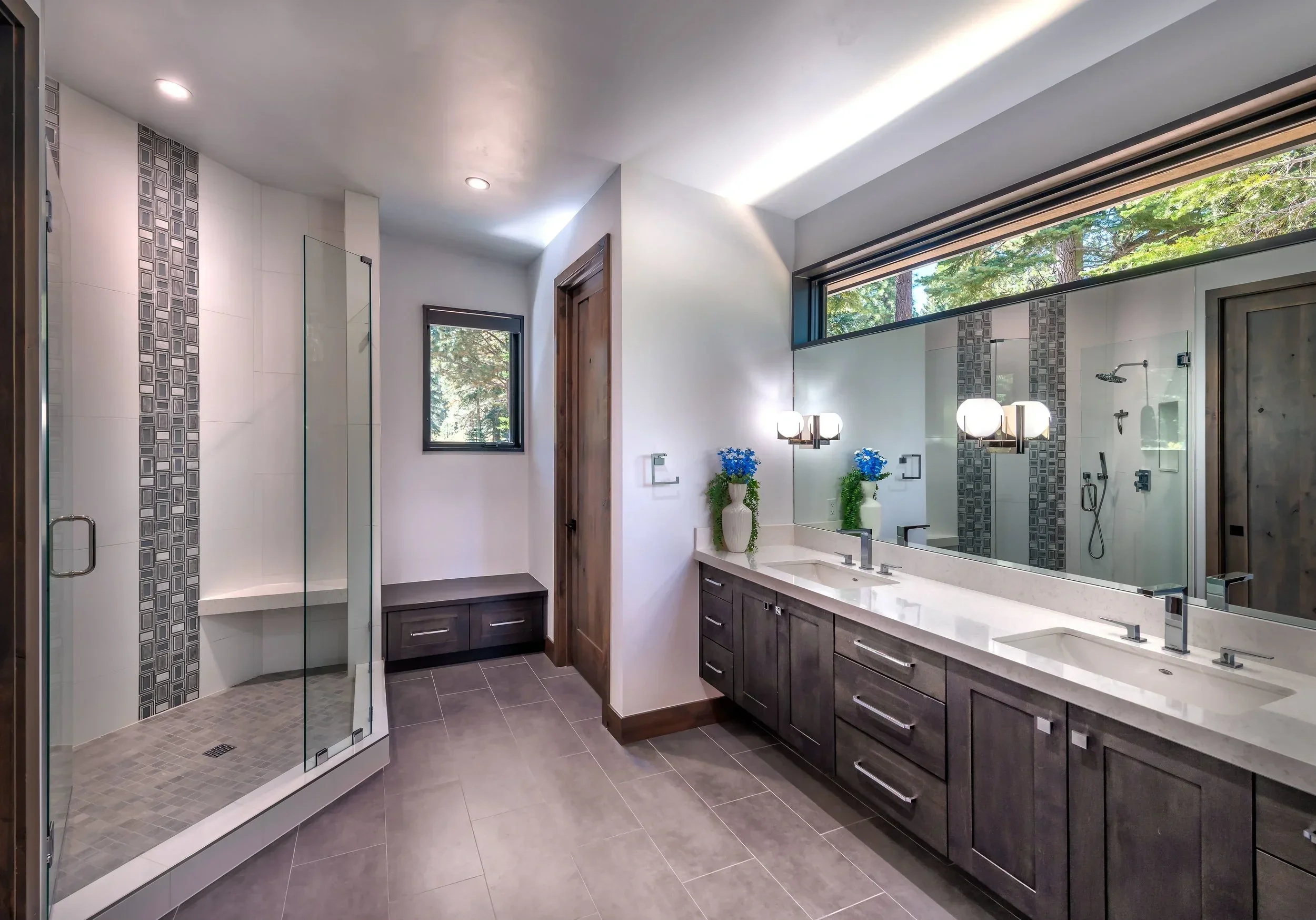 Modern bathroom with a double vanity, large mirror, and a walk-in shower with a glass door.