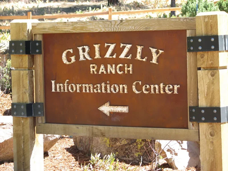 A wooden sign for the Grizzly Ranch Information Center with an arrow pointing left.