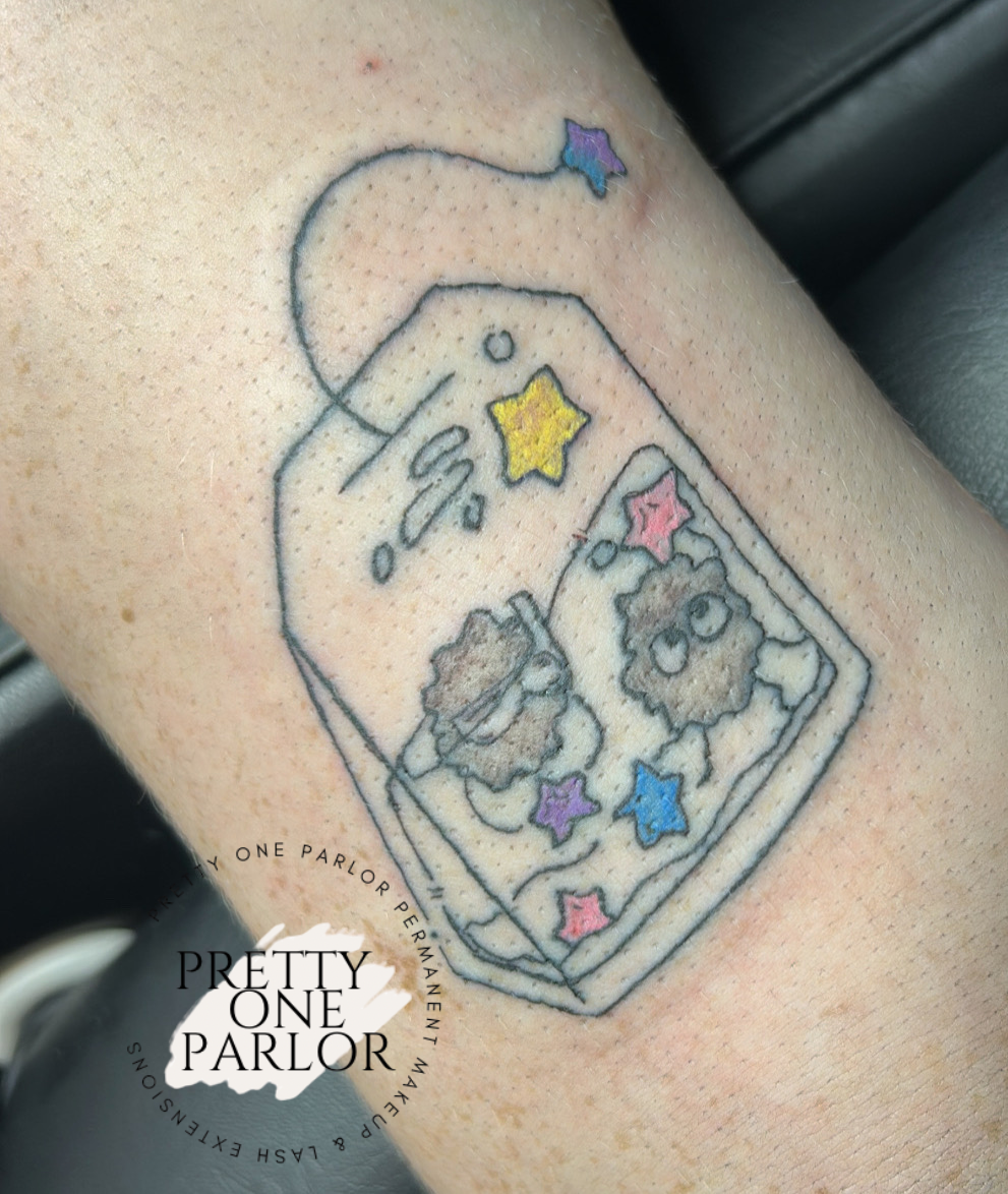 Tattoo of a soda can with two cartoon characters inside, surrounded by colorful stars.