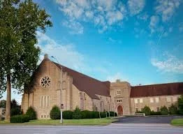 Silhouette of a soldier saluting against an American flag overlay and a sunset sky.