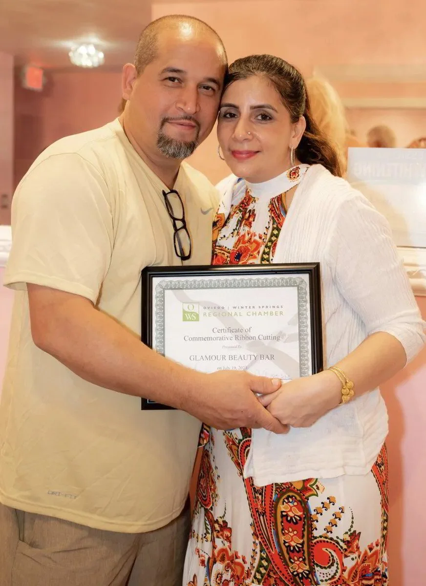 A man and a woman holding a framed certificate at a ceremony.