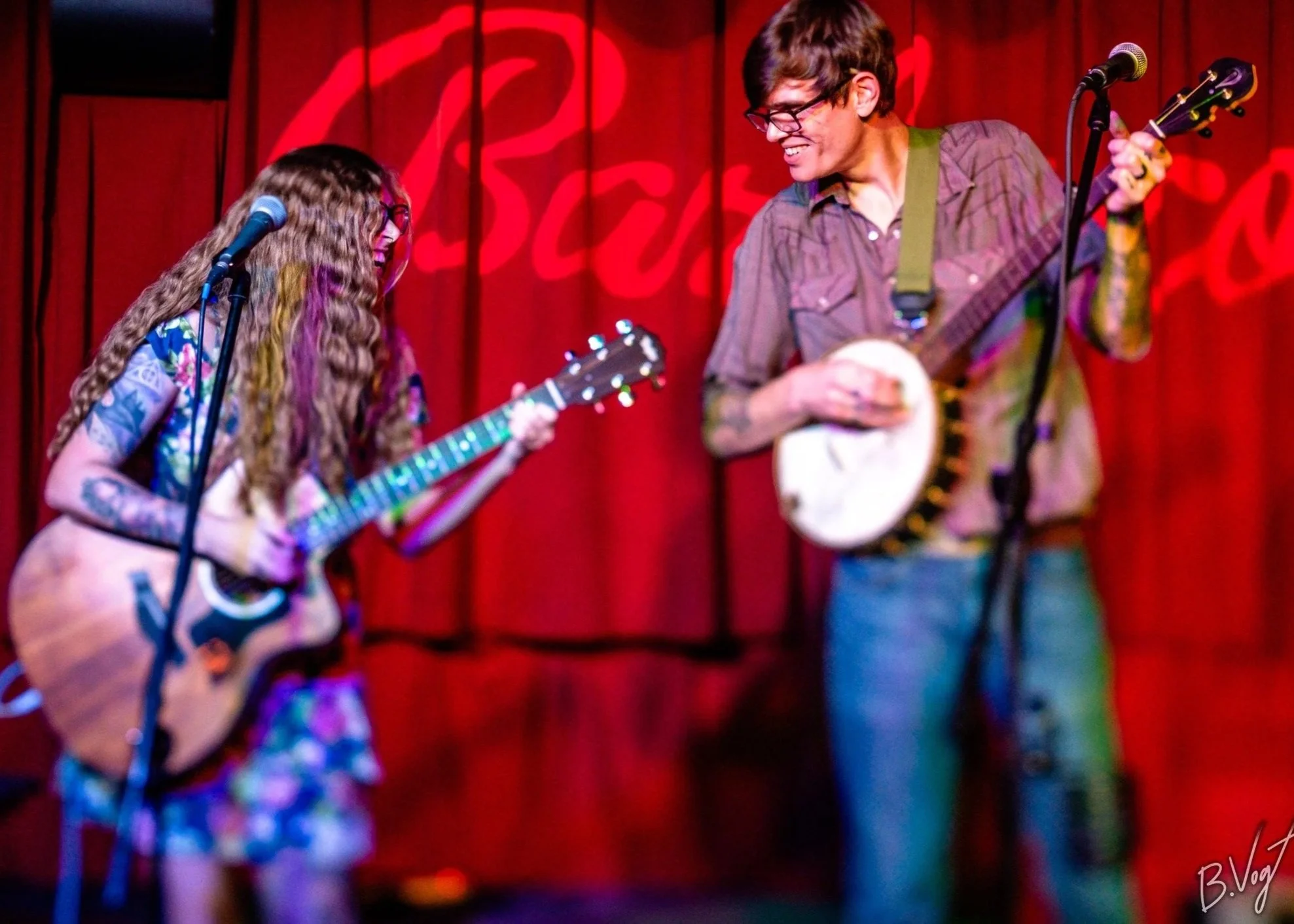 Photo by Vogt Photography of Rachel & Griffin at Barleycorn's in front of their red velvet backdrop in Wichita, Kansas. 