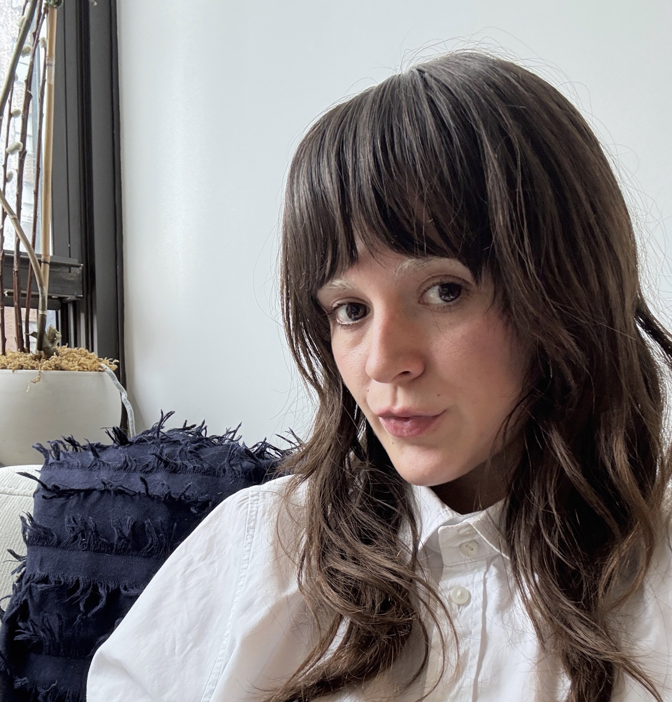 A black and white portrait of a woman with long dark hair, looking at the camera with a slight smile.