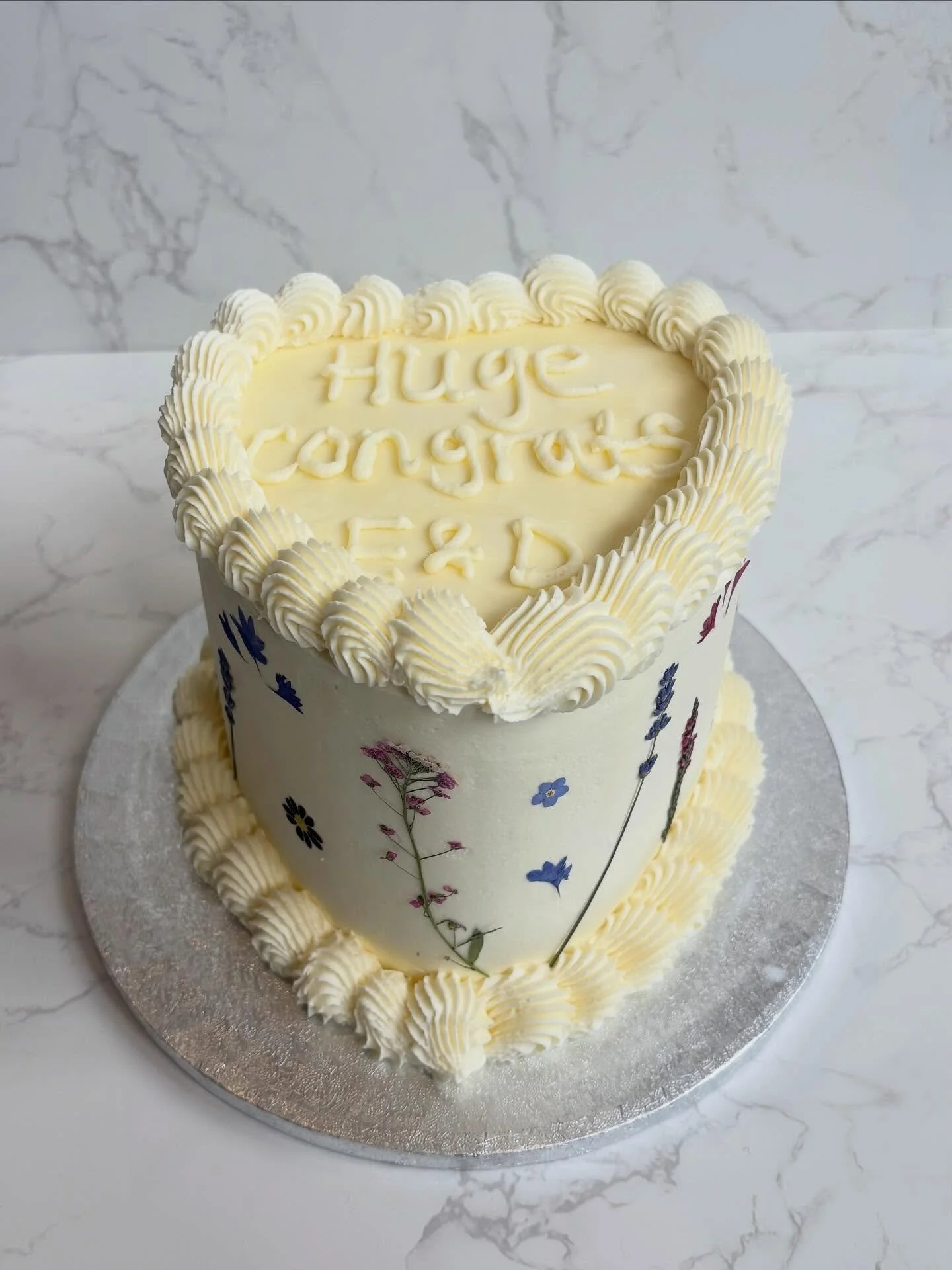 Maybe it&rsquo;s the &lsquo;Flora&rsquo; in me (&lsquo;scuse the pun!), but pressed flowers always win 🤍✨ 

A heart shaped engagement cake made with a red velvet sponge and vanilla buttercream 💍 🌸 🩷

#engagementcake #redvelvet #bakesbyflo