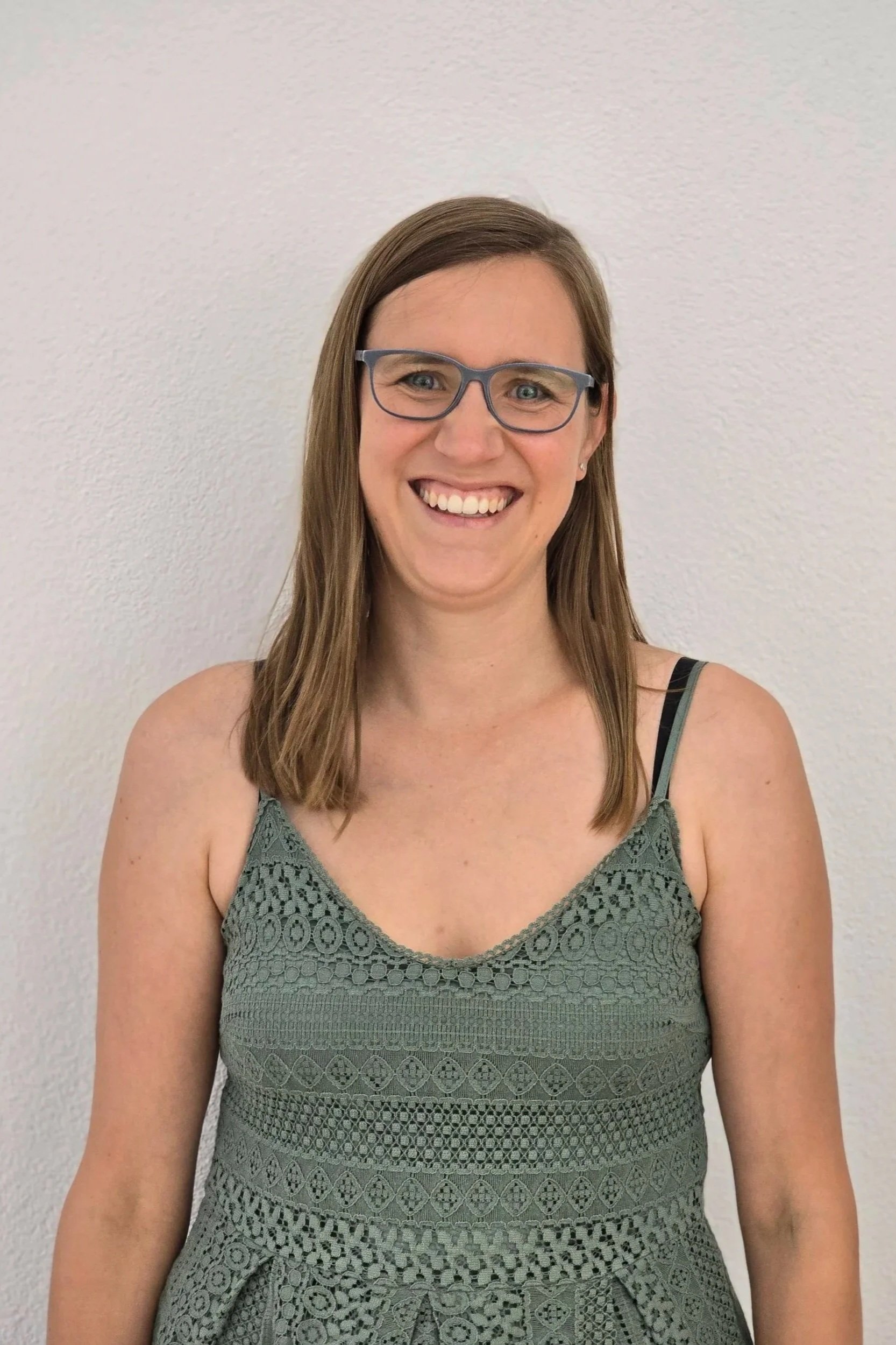 Bettina mit Brille, lächelt in die Kamera