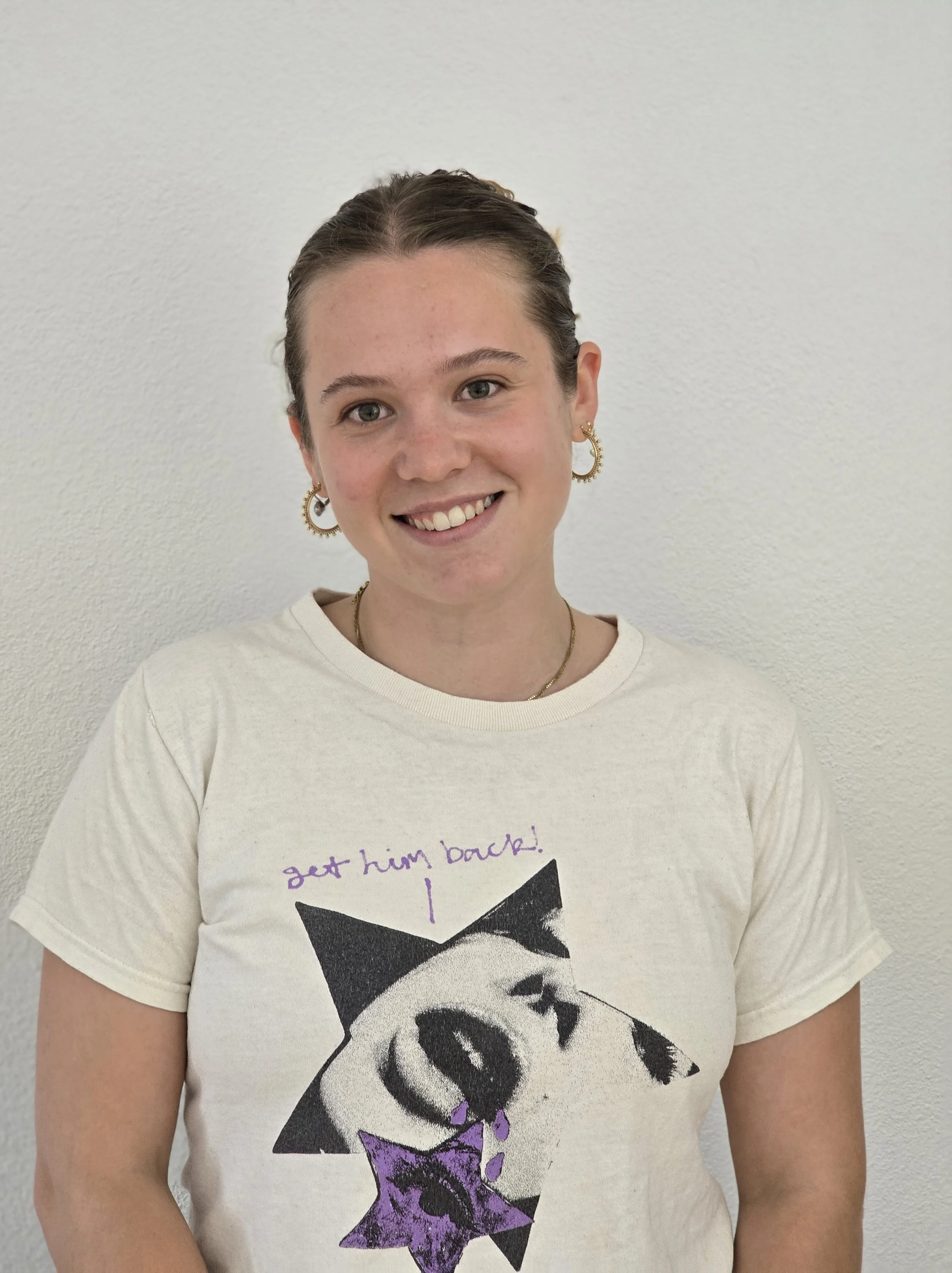 Delia mit zusammengebundenen Haaren, lächelt in die Kamera