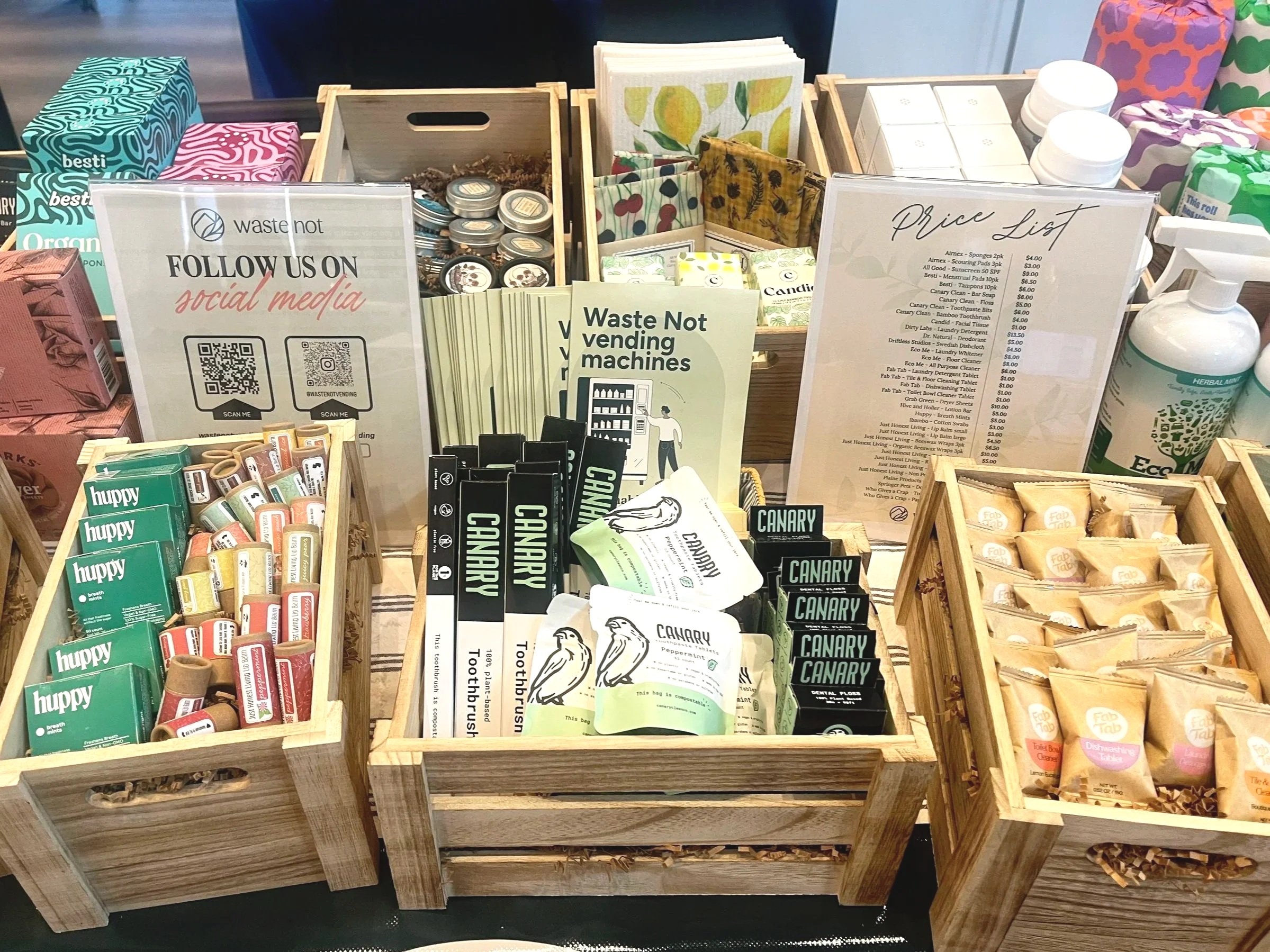 Wooden box crates filled with personal care items like lip balm, tooth brushes, toothpaste tablets, lotion, etc