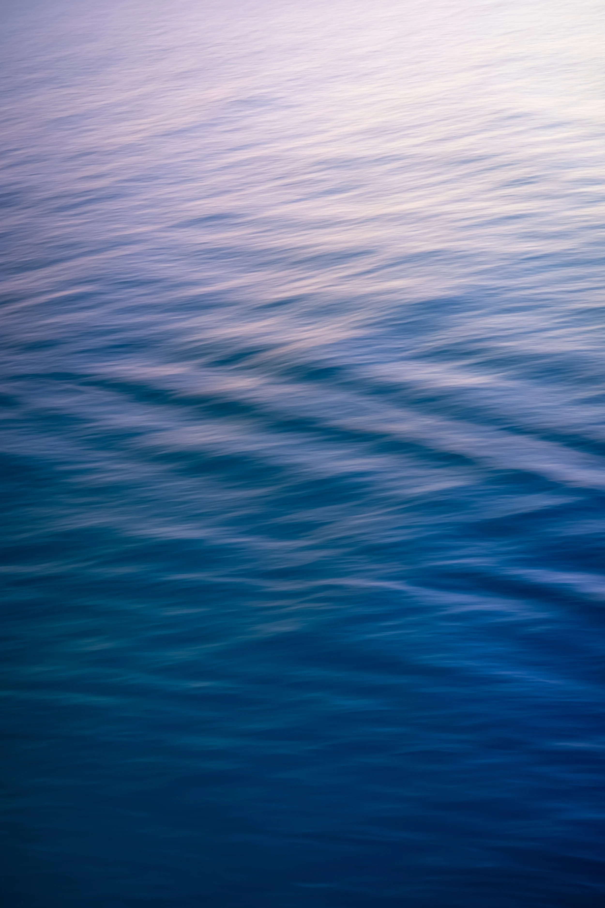 Calm ocean water with gentle ripples at sunset or sunrise.