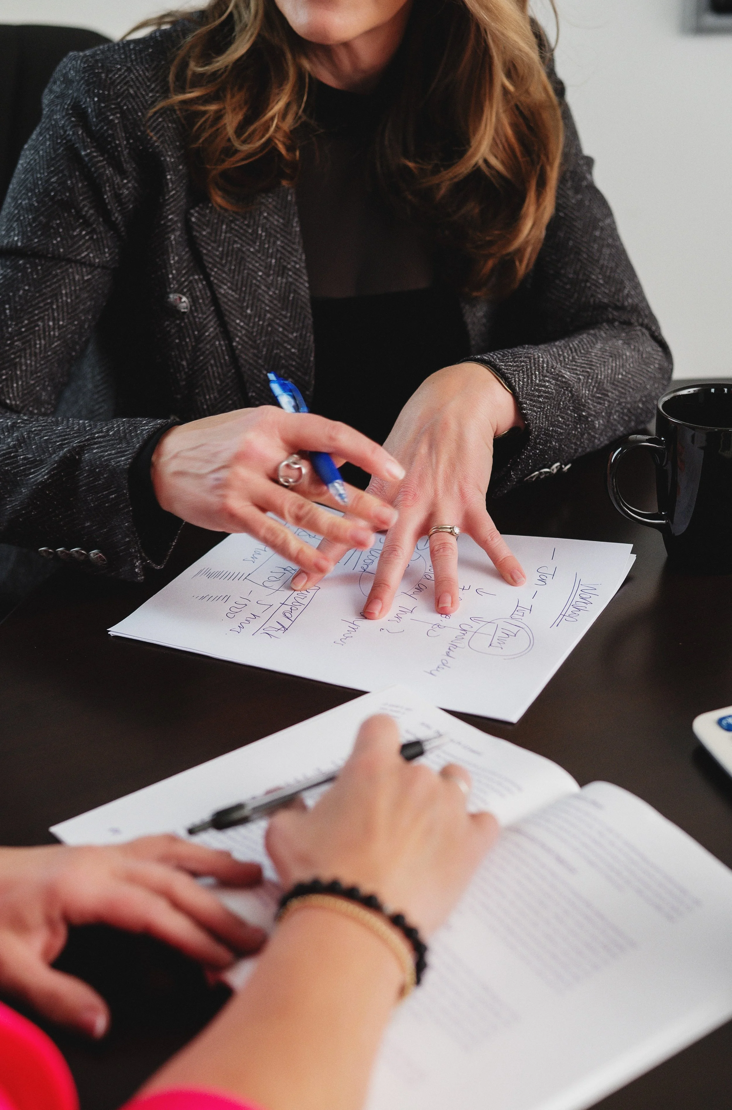 Separation and divorce coach Lana Wickstrom in Saskatoon is discussing notes and writing on sheets of paper during a meeting.