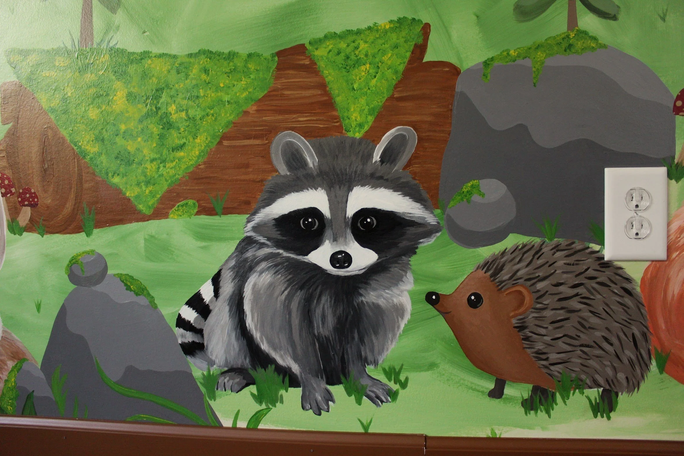 Colorful mural of a raccoon and a hedgehog in a forest scene with rocks, trees, grass, and mushrooms.