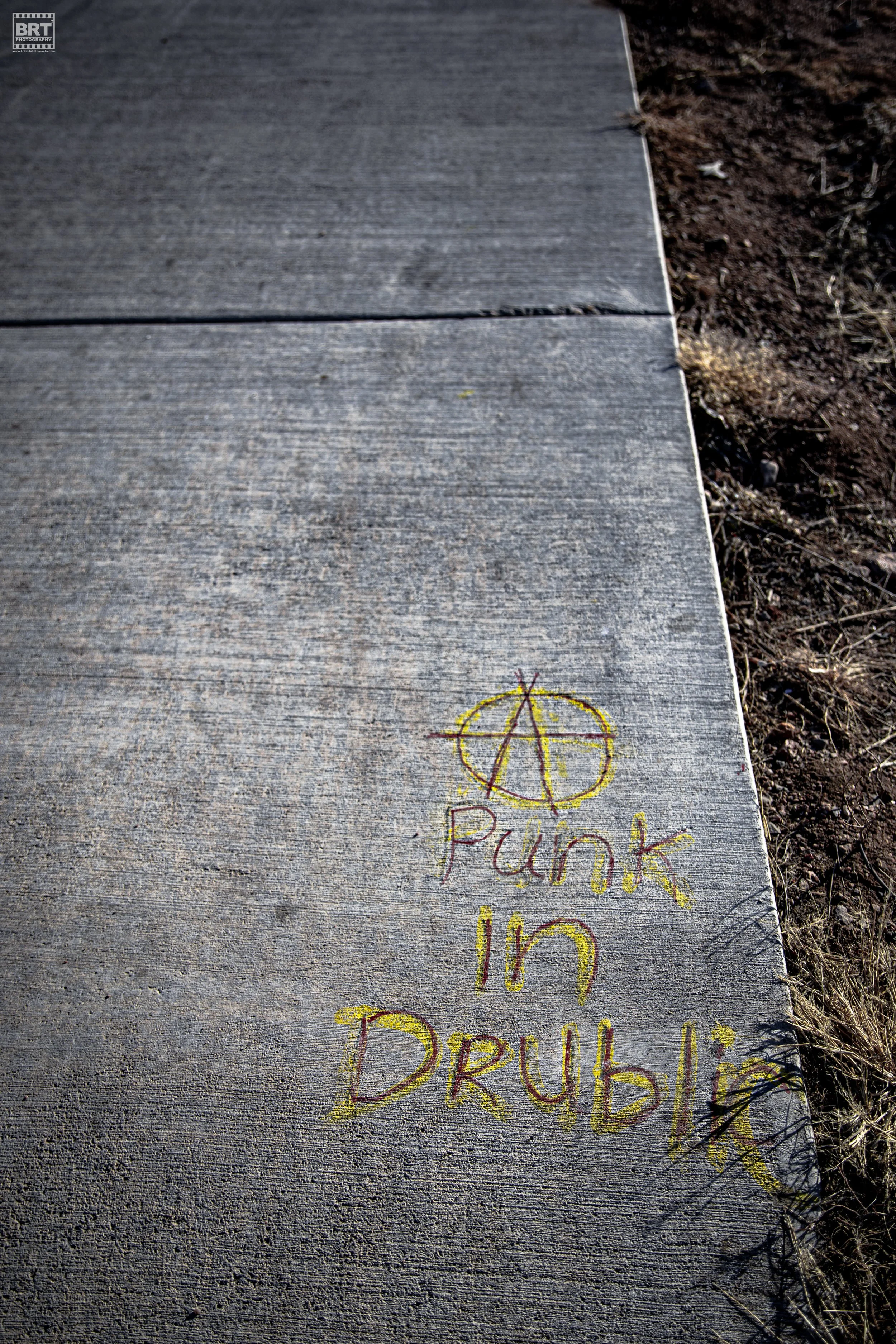 Walkway with graffiti that says 'Punk in Drublik' and features a peace symbol