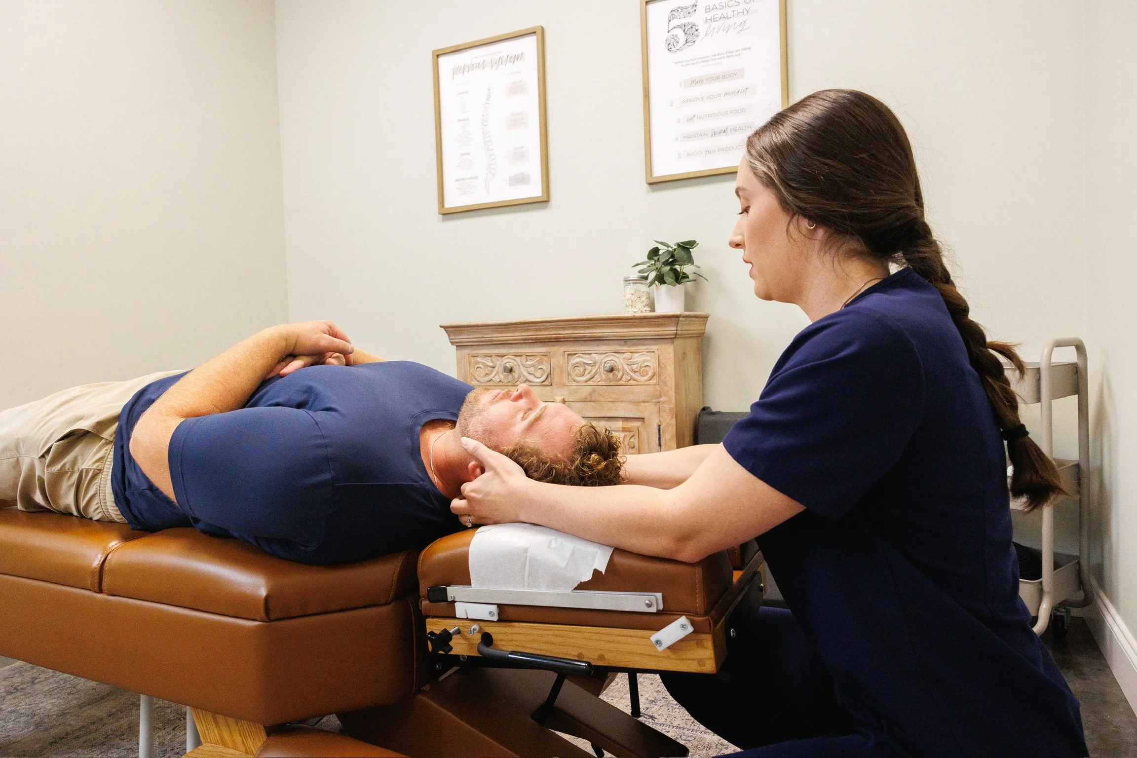 Medical professional examining a patient lying on an examination table.